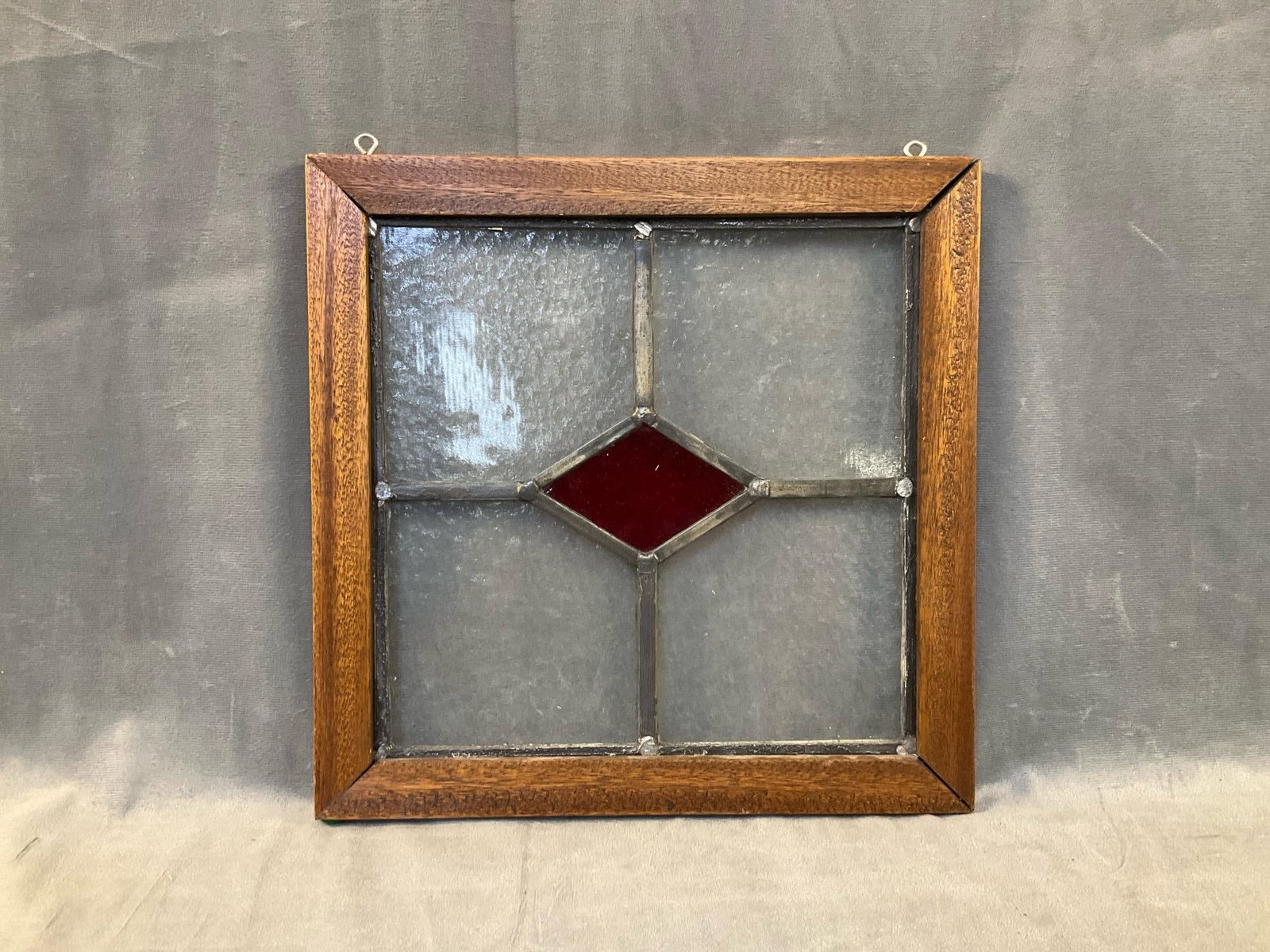 Stain Glass Window: Late twentieth century decorative hanging stain glass window in wooden frame. Good condition. Measures 12 inches wide x .75 x 12 inches tall.