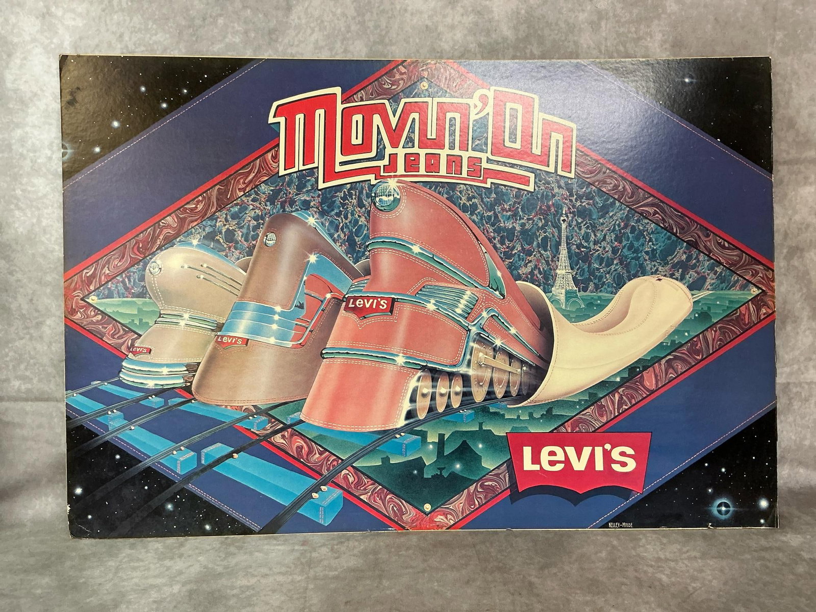 Levi's "Movin' On" Poster: 1970's Levi's poster. Movin'On jeans poster, art by Kelley-Mouse Studios. Some slight color fading and bent corners. Measures 31 inches wide x 20.75 inches tall.