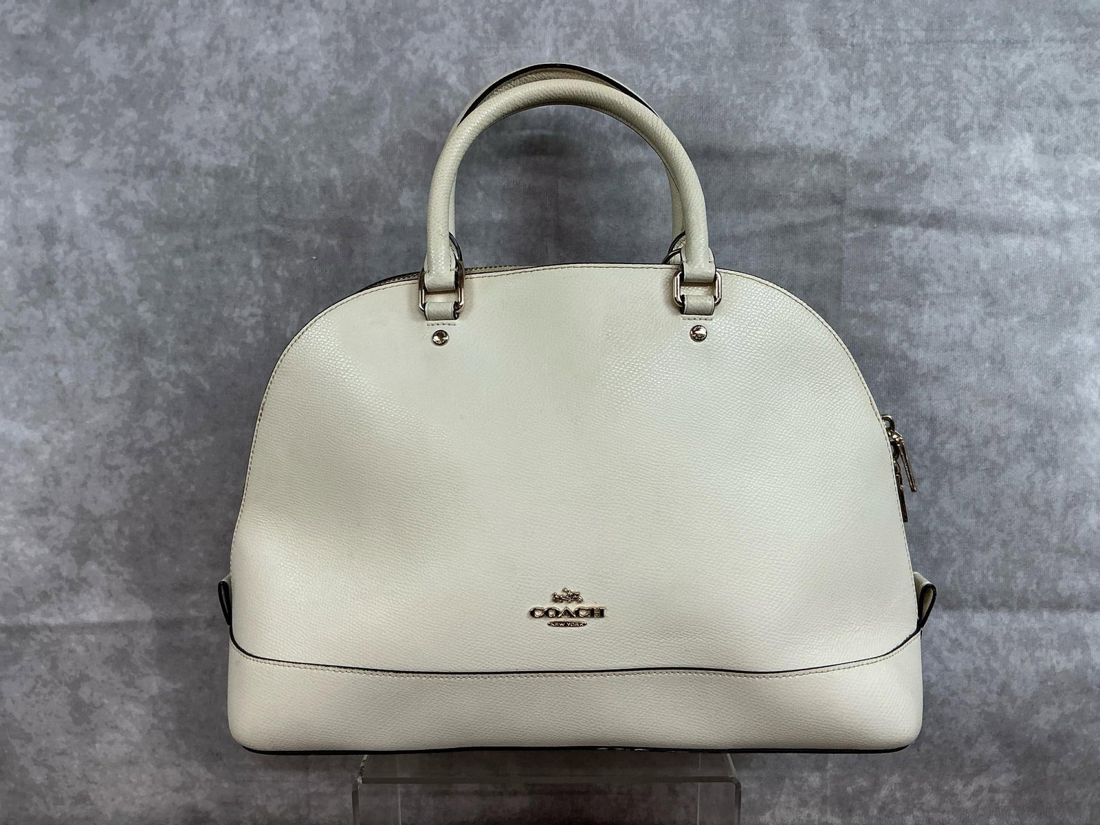 Coach Sierra Satchel: Modern leather Coach crossbody handbag with cloth interior and brass colored hardware. Small exterior pocket, two interior side pockets, and one interior zippered pocket. Missing crossbody strap,