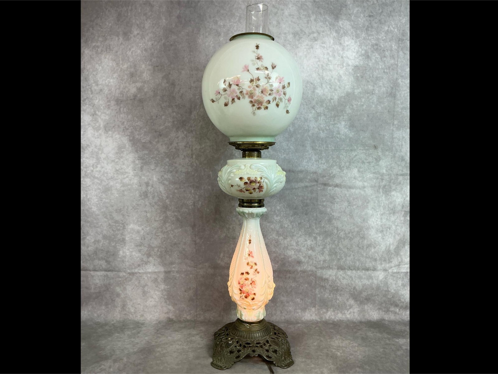 Victorian Parlor Lamp: Late 1800's metal and glass parlor lamp. Converted to electric. Delicate pink and yellow floral design. Switch is stuck, only base lights up. Missing one prong near base of top round globe. Measures