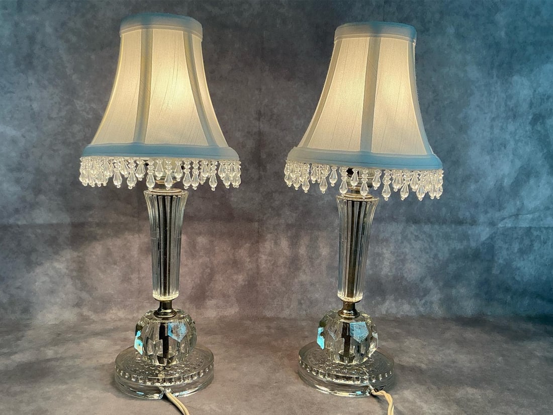 Boudoir Lamps: Two mid 1900's small lamps. Made of pressed glass with white fabric shades and dangling crystals. In good condition. Each measures 4 inches in diameter at base x 15 inches tall.