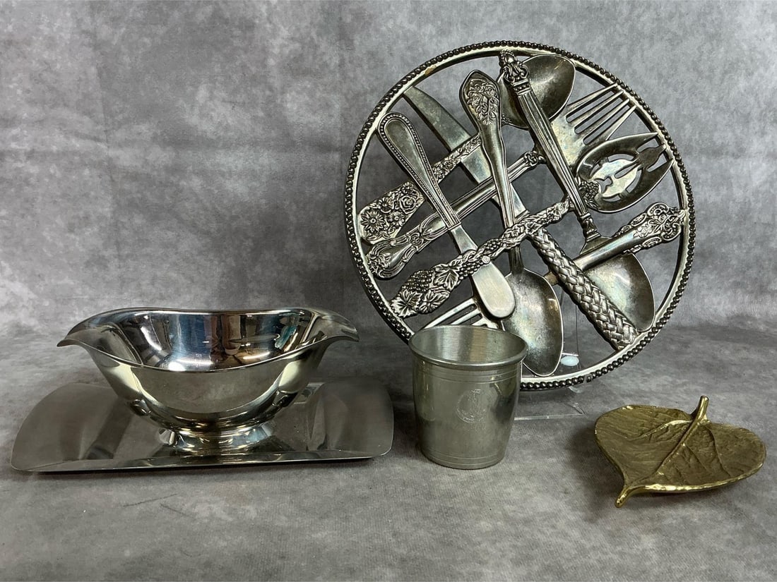 Metal Serving Pieces: Four mid to late 1900's metal pieces. Brass Mulberry Leaf by Virginia Metal Crafters, stainless Tramontina gravy boat with attached tray, Godinger Silver Art Co trivet made of flatware, and Camelot