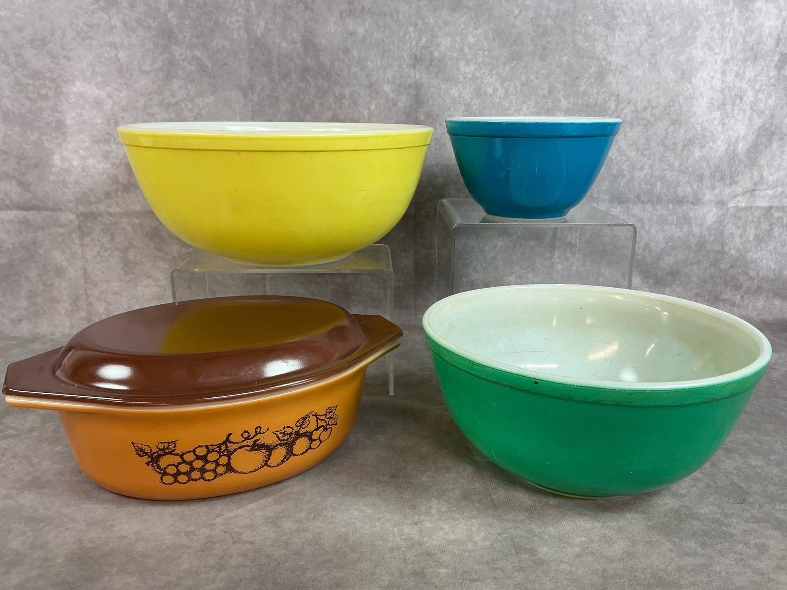 Pyrex Mixing Bowls & Casserole: Four mid 1900's Pyrex dishes. Primary Colors 3 piece mixing bowl set and Old Orchard brown and tan 1.5 quart size casserole dish with lid. Inside of bowls are scratched, otherwise in good condition. Y