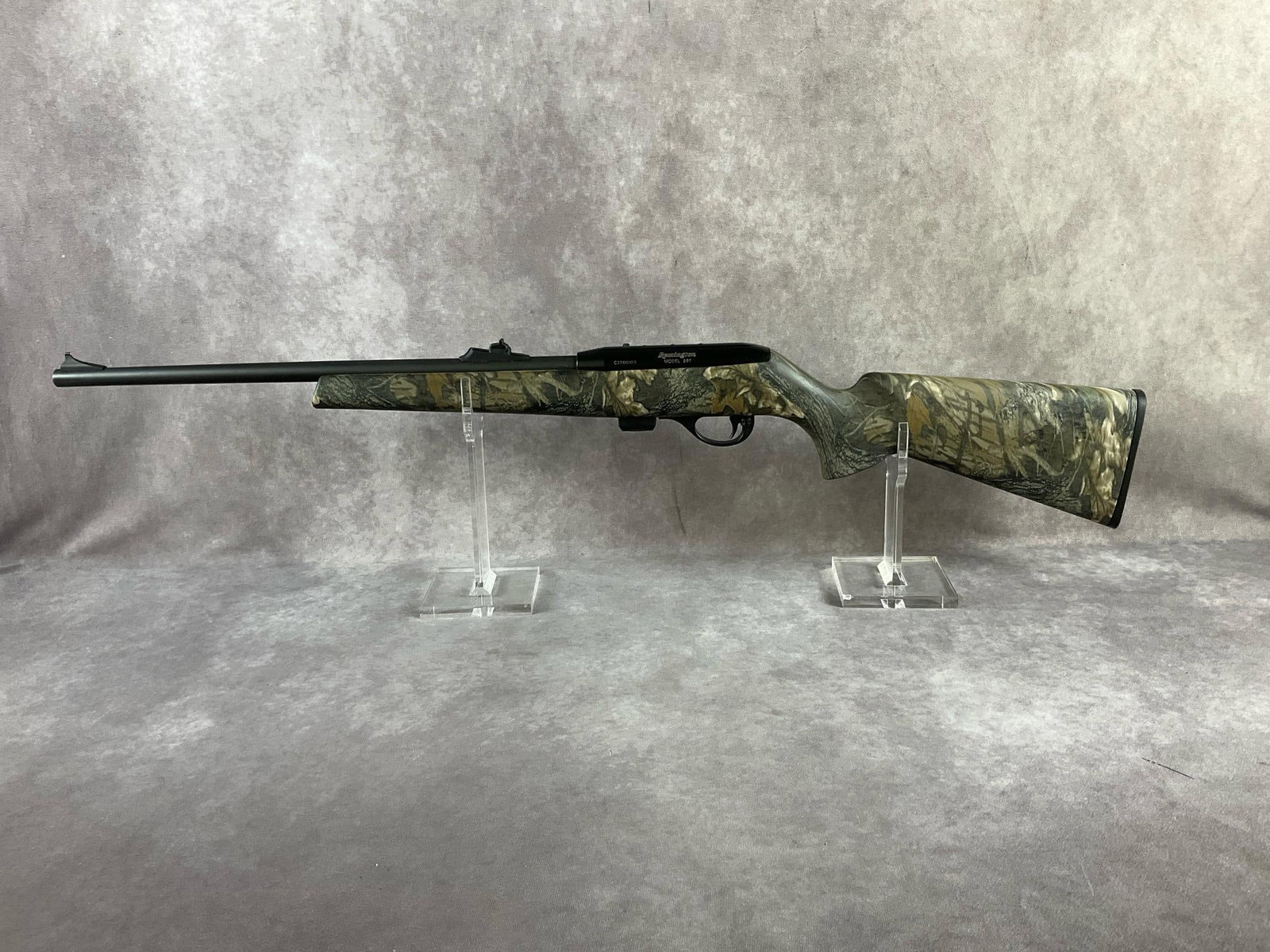 Remigington 22 LR Rifle: Serial # C2700103 Model 597 22LR semi-automatic rifle. Black steel components with camo synthetic stock. Clean bore and functions correctly. Includes soft side case. Barrel length 20 inches, overall