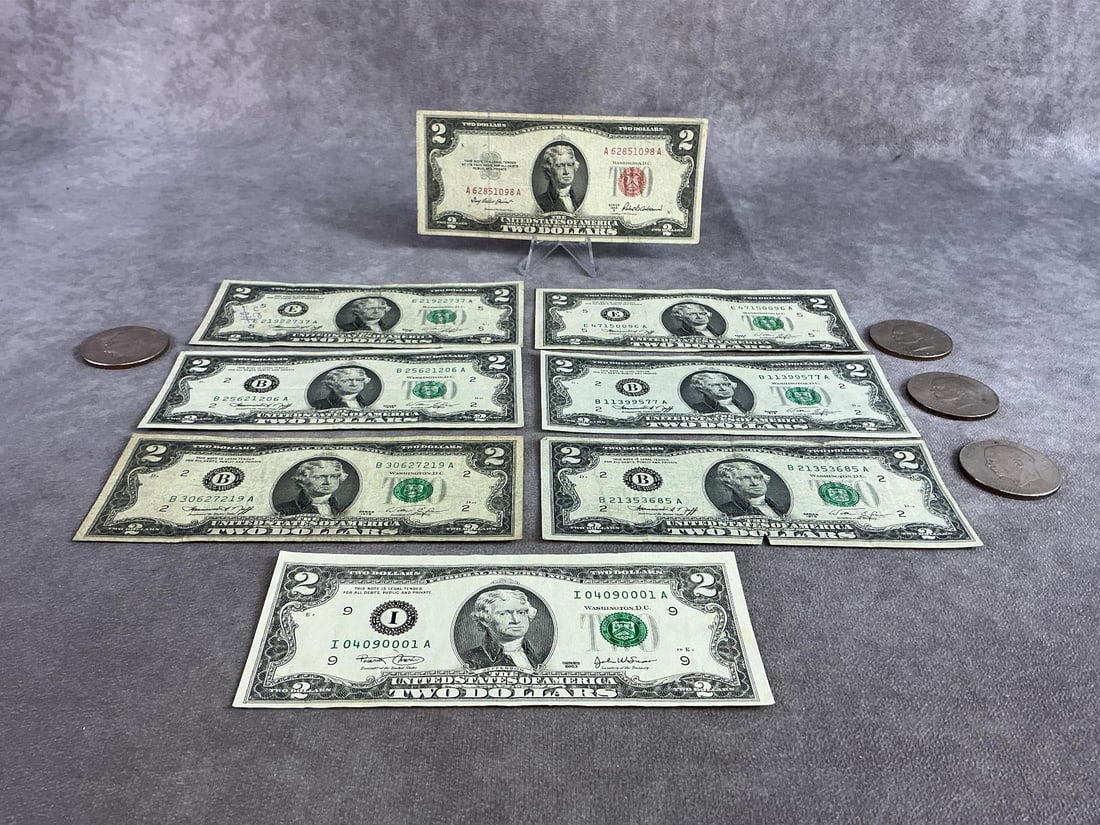 Jefferson Two Dollar Bills & Ike Coins: Eight Thomas Jefferson two dollar bills including one red seal from 1953 and four Dwight Eisenhower Dollar Coins. All in good condition and circulated. Each bill measures 6.15 inches wide x 2.65