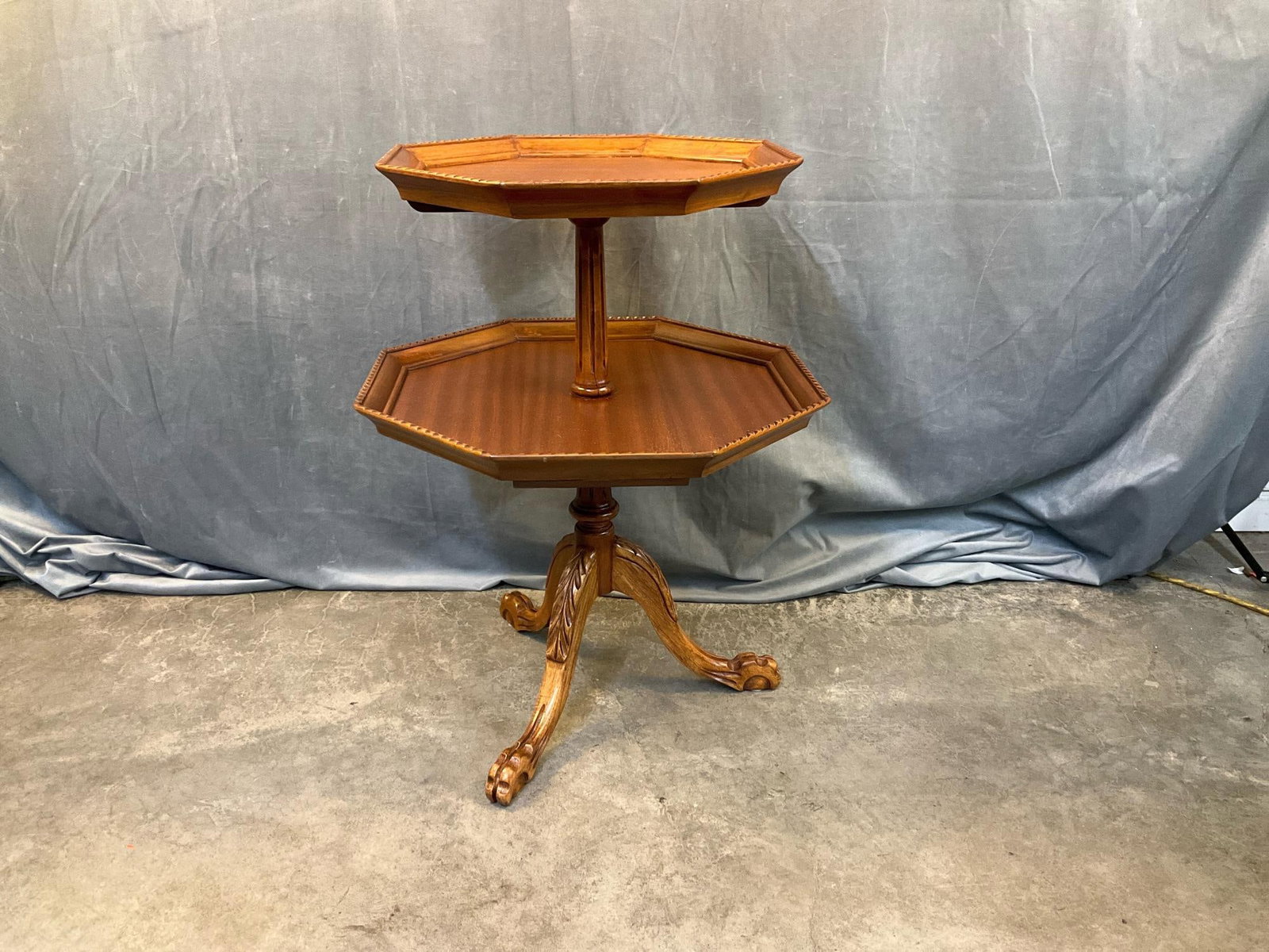 Dumbwaiter: Mid - twentieth century two tiered mahogany Chippendale style dumbwaiter. Zuk Manufacturing label attached underneath bottom tier. Good condition. Measures 22.25 inches wide x 22.25 x 30 inches tall.