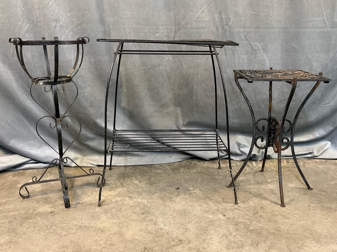 Iron Plant Stands: Three mid-20th century iron plant stands. Largest two tier stand with slight bend to top, and collapsible stand with flaking paint, otherwise good condition. Two tier stand measures 19.5 inches wide
