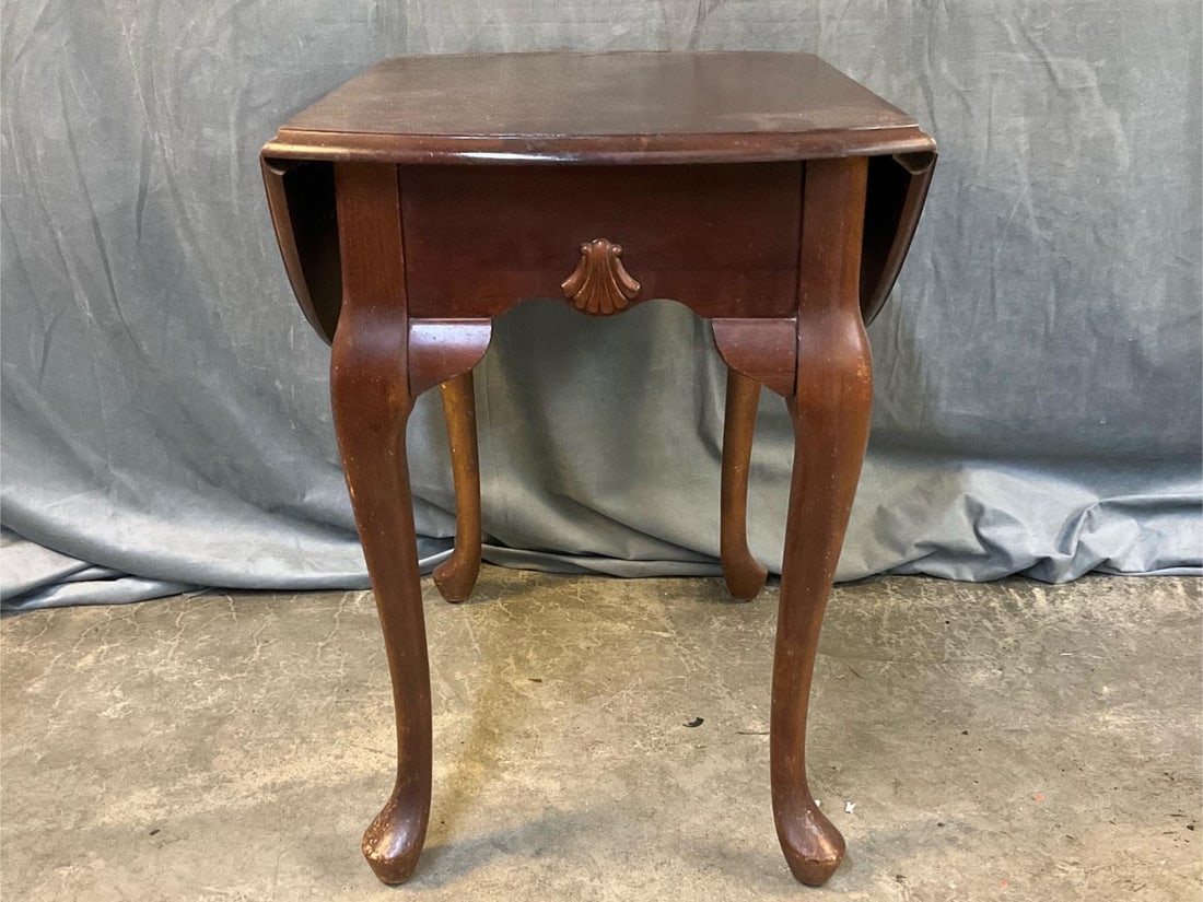 Side Table: Late 20th century Mahogany Queen Anne Style Drop Leaf Side Table with carved shell and pad feet. Scratches to finish, otherwise good condition. Measures 18 inches wide x 24 x 24 inches tall.