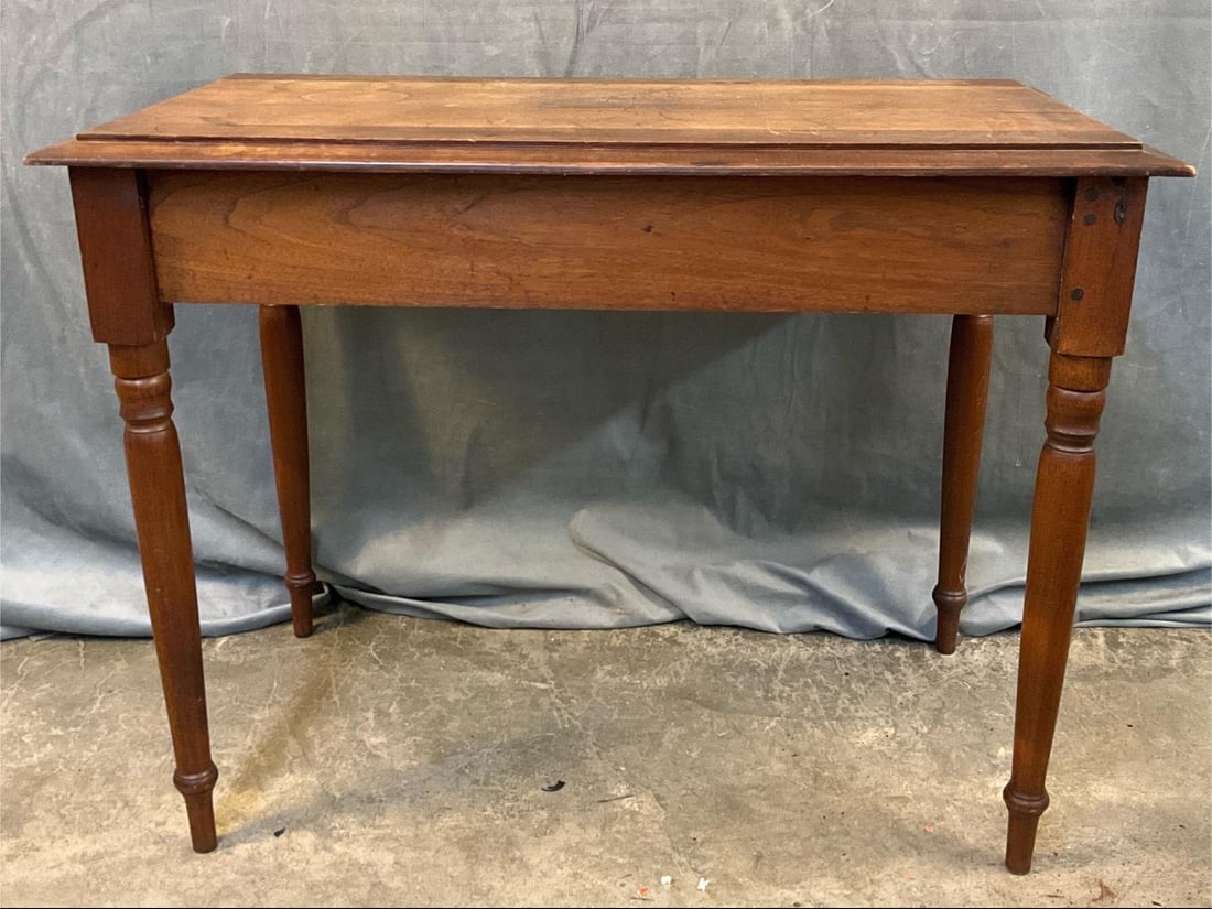 Side Table: Mid-19th century walnut side table with turned legs, and beveled raised top. Separation to top with crack to top, and three legs repaired at rail and leg joints using tenons. Mid-Atlantic, probably