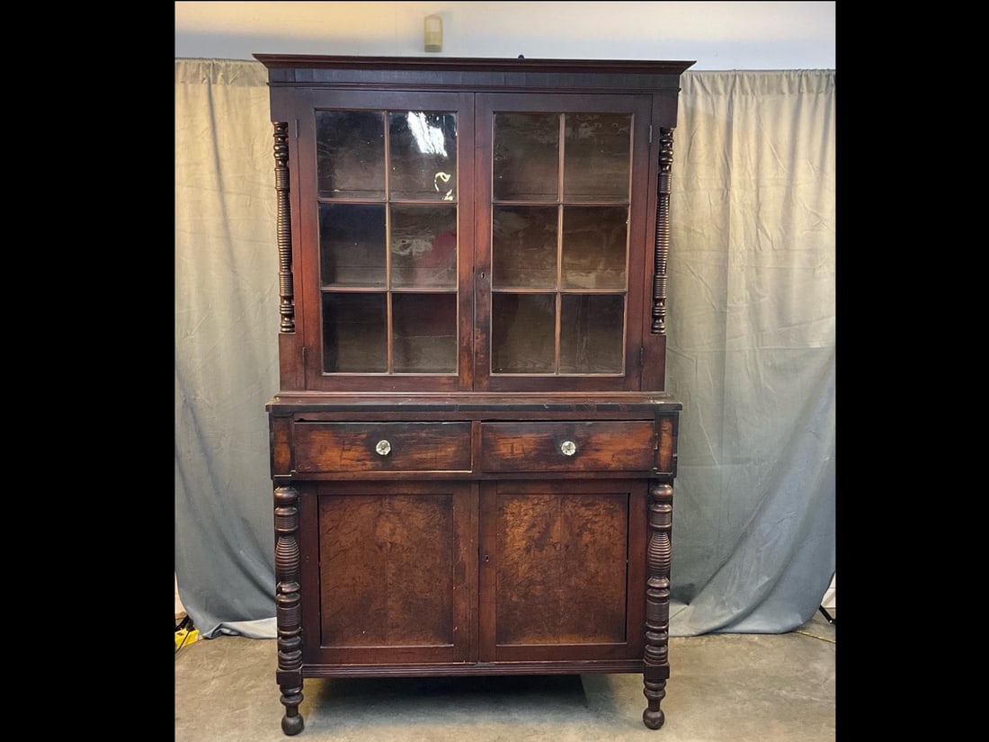 China Press Cupboard: Mid-19th century Victorian/Empire Period China/"Jackson Press” Veneered Cupboard. Two glass doors over two lower blind doors, spool turnings, later replaced glass drawer pulls, ball feet, and