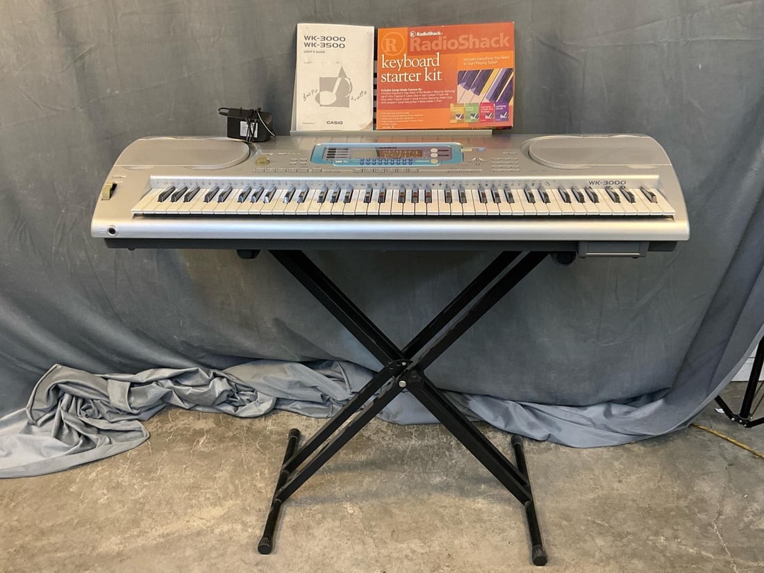 Casio Keyboard: Circa 2000 Casio WK-3000 Keyboard with stand, Radio Shack Keyboard Starter Kit, and Casio User's Guide. Tested and works. Good condition. Measures 46.75 inches wide x 17.5 x 6.5 inches tall.