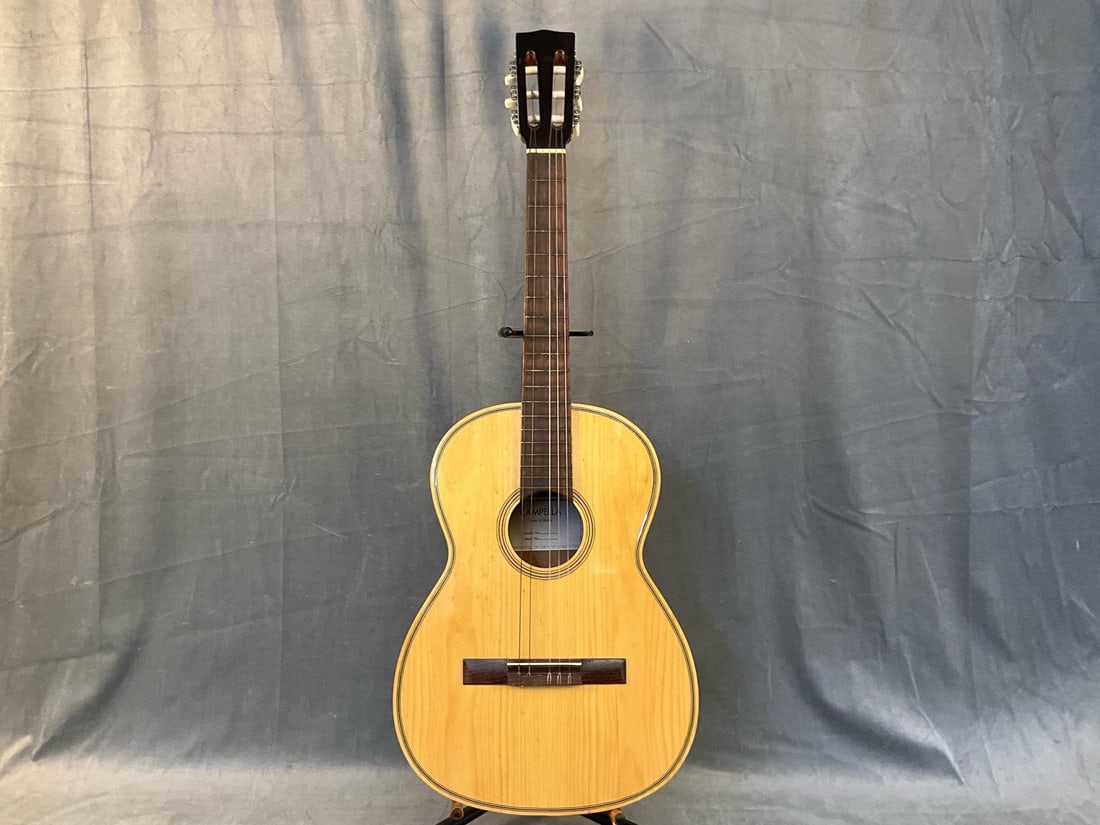 Classical Acoustic Guitar: Late 20th Campella (Made in Brazil) Classical Acoustic Guitar with case. Split to body top. Measures 37.5 inches wide x 3.75 x 14 inches tall.