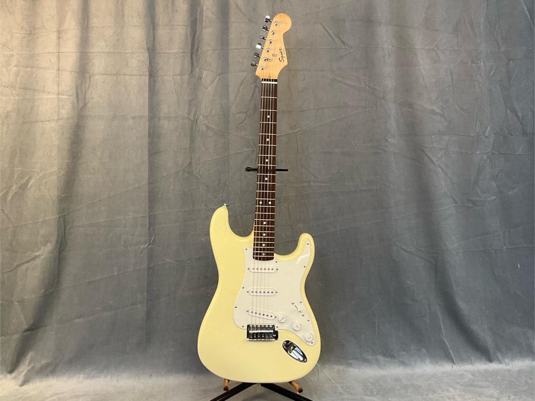 Fender Electric Guitar: Late 20th century vintage Fender Squire Bullet Strat. Serial number - COB71229301. Includes soft case. Small scratches to body, and two small cracks to body where the neck meets, otherwise good