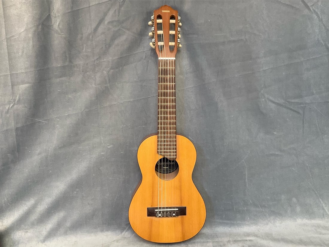 Yamaha Guitalele: Circa 2000 Yamaha GL-1 Guitalele with soft case. Good condition. Measures 9 inches wide x 2.75 x 29 inches tall.