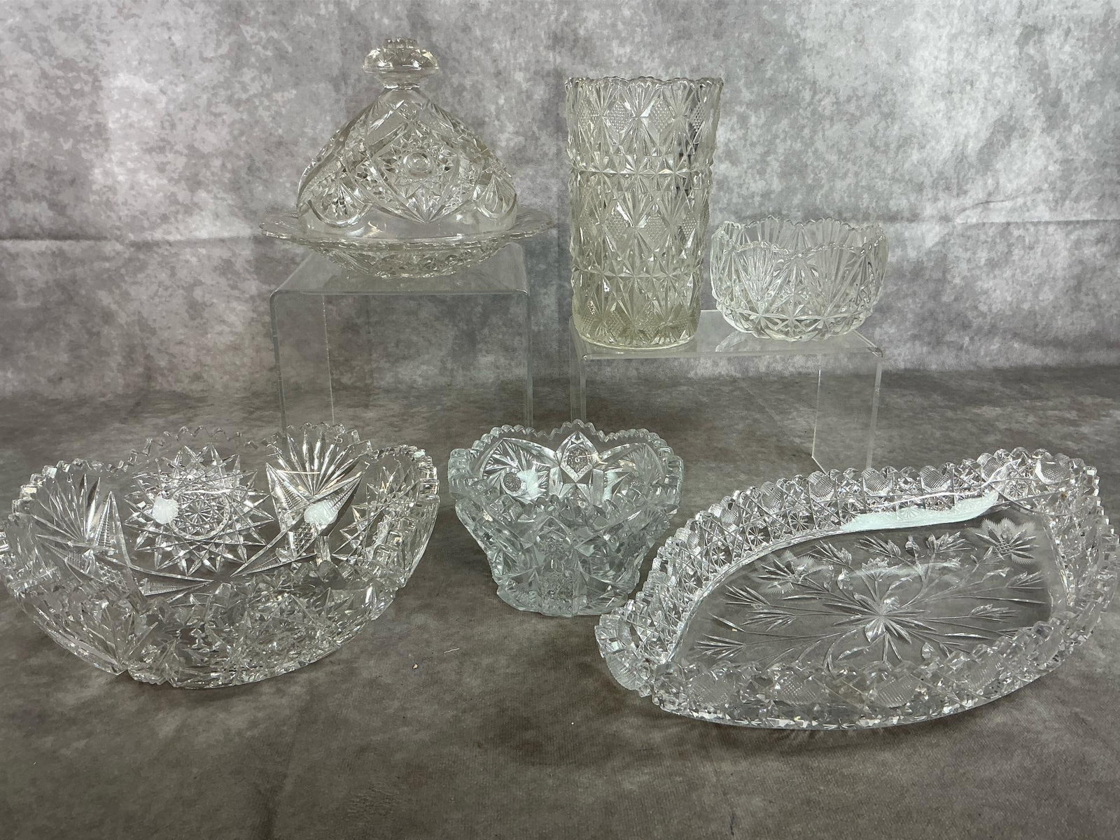 American Brilliant Cut Glass: Six mid to late 1900's cut glass dishes. Includes canoe shaped relish tray, butter dish with lid , star pattern American Brilliant bowl, two smaller bowls, and vase. All in good condition. Tray
