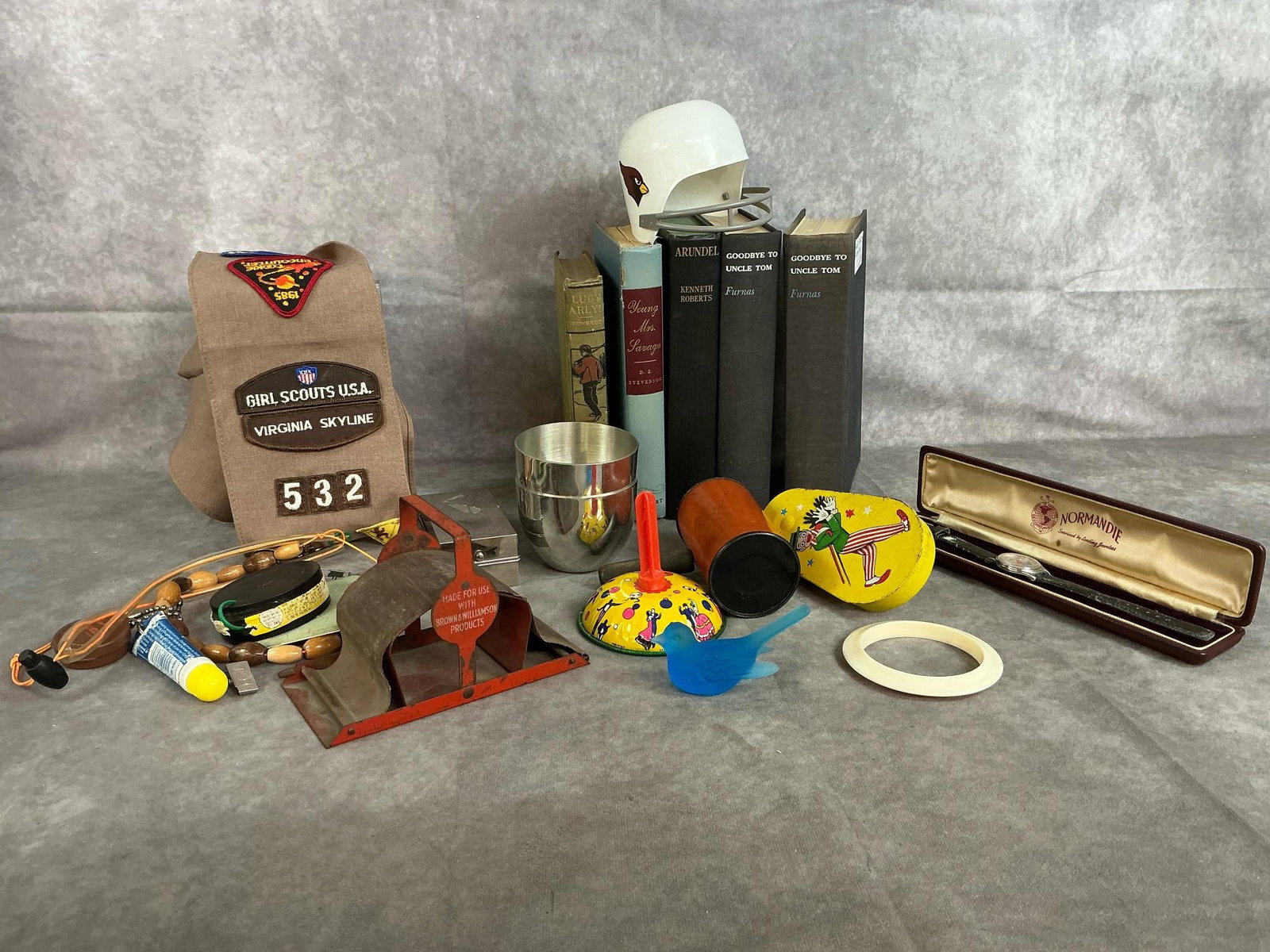 Books, Noise Makers, Cigarette Roller, & More: Eighteen vintage finds. Five books, Girl Scout VA Sash, antique Brown & Williamson cigarette roller, backwards Goofy watch, three noise makers, Westmoreland glass blue bird, and more. Wear,
