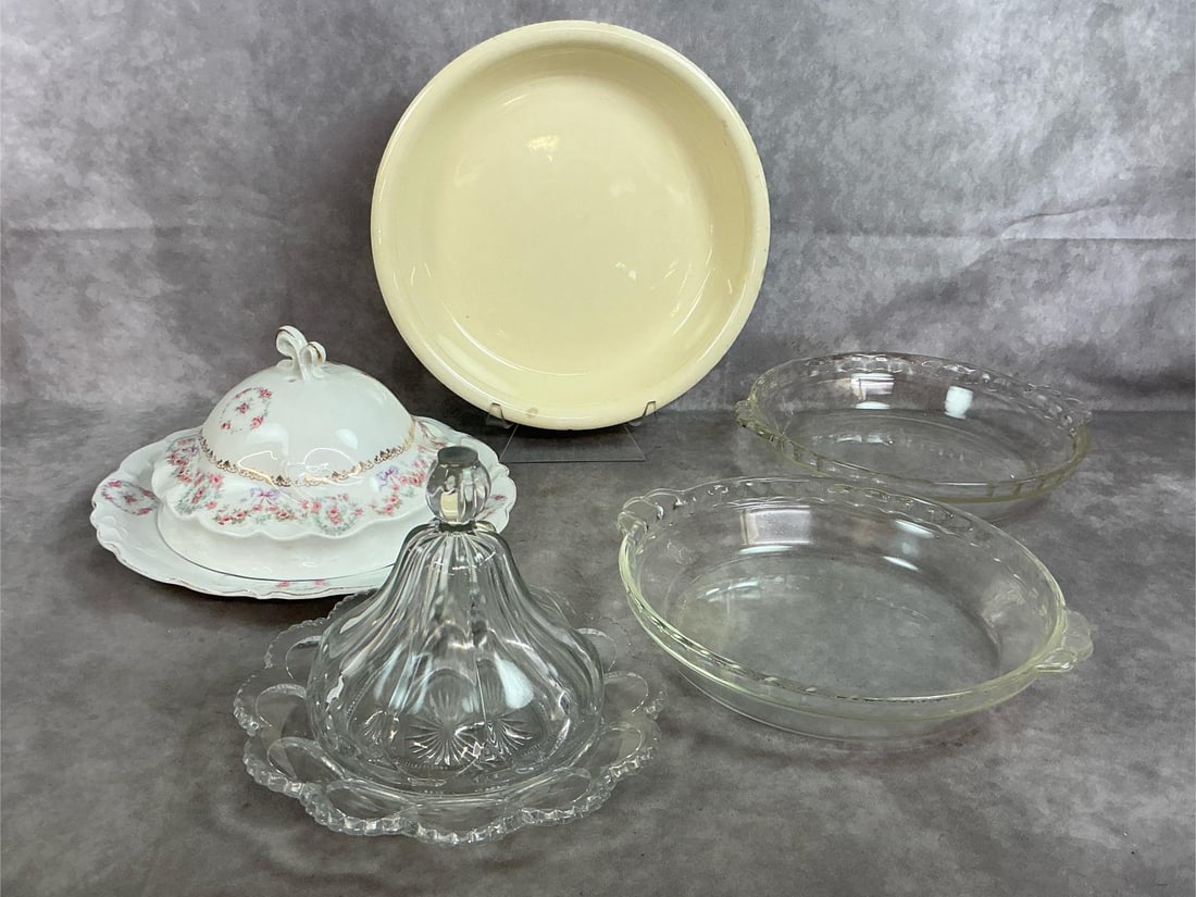 Butter Dishes and Pie Plates: Five mid to late 1900's glass and porcelain pieces. Heisey covered butter dish, Peerless pattern #300, and German covered porcelain pink and blue rose garland butter dish. Includes cream colored