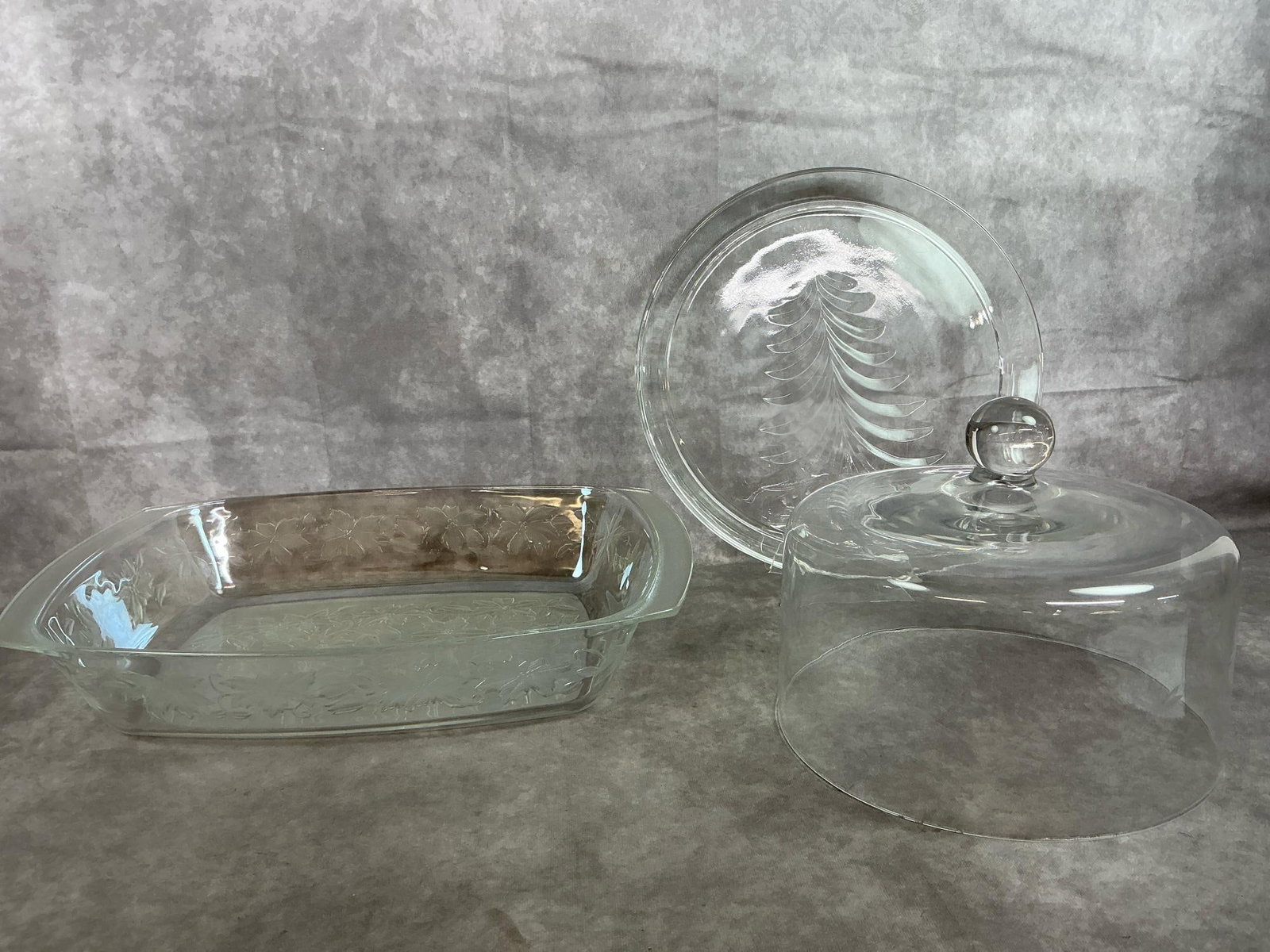 Princess House & Indiana Glass Holiday Pieces: Three pieces of crystal glassware. Princess House Fantasia lasagna dish with frosted poinsettias. Princess house Heritage glass cake dome, and Indiana Glass Homefinds platter with Christmas tree. In