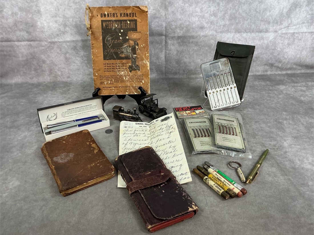 Antique Pocket Notebook, Spelling Book, Calculators, & More: Collection of vintage and antique items. Three "pocket calculators", capped advertising pencils, set of Ruritan pens, train and auto pencil sharpeners, and McCormick-Deering Cream Separater manual.