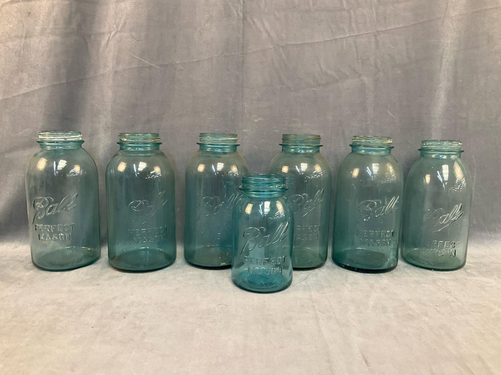 Mason Jars: Lot of seven early-mid 20th century "Perfect Mason Jars”. Two with chips, several with flea bite chips, otherwise good condition. Measures 4 inches in diameter x 6.75 inches tall.