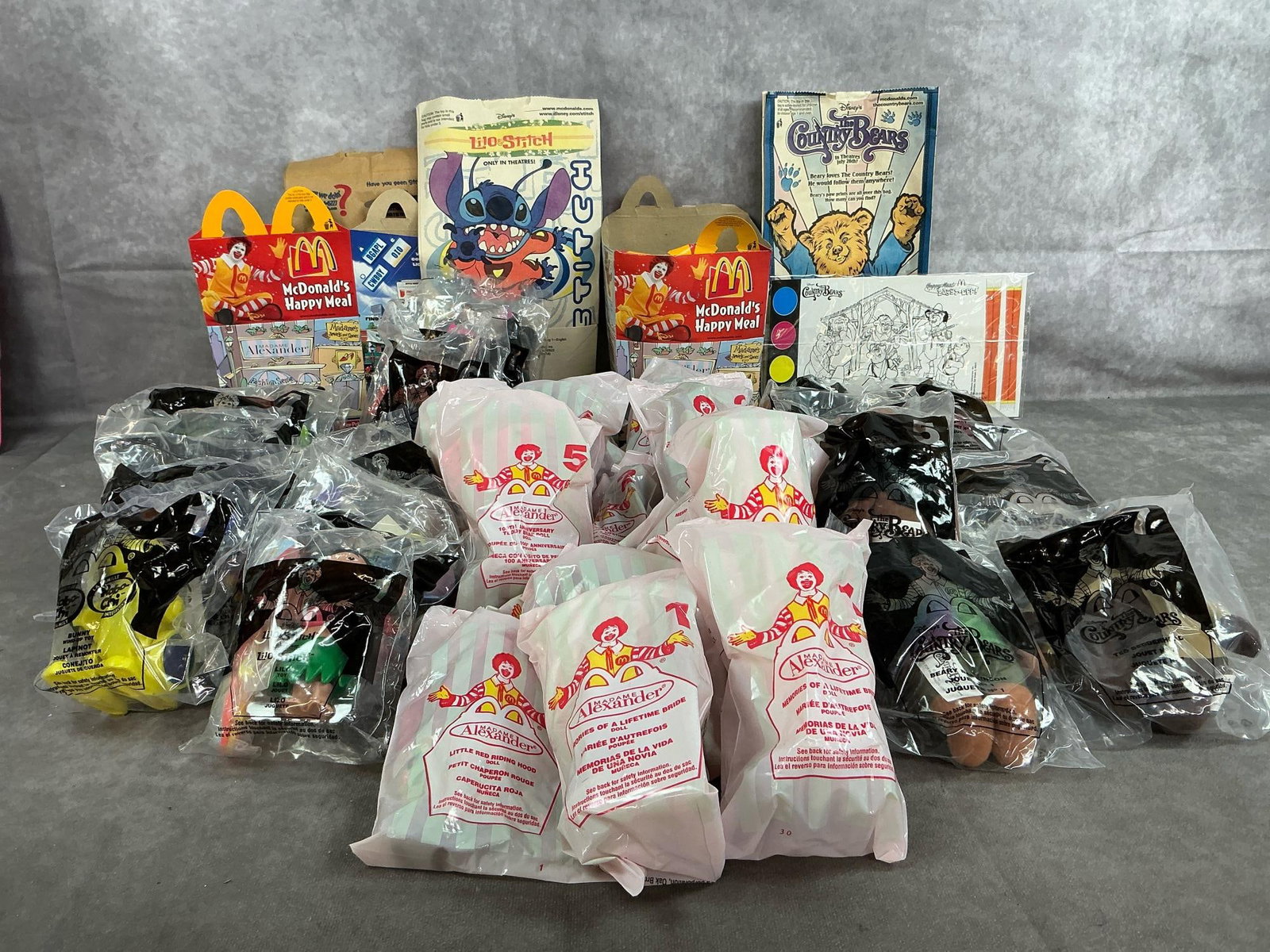 McDonald's Toys: Thirty-five 2001-2002 Happy Meal toys. Includes Country Bears, Madame Alexander, Lilo Stitch, and Robo-Chi. In original packaging. Measures 4 inches wide x 5 inches tall.