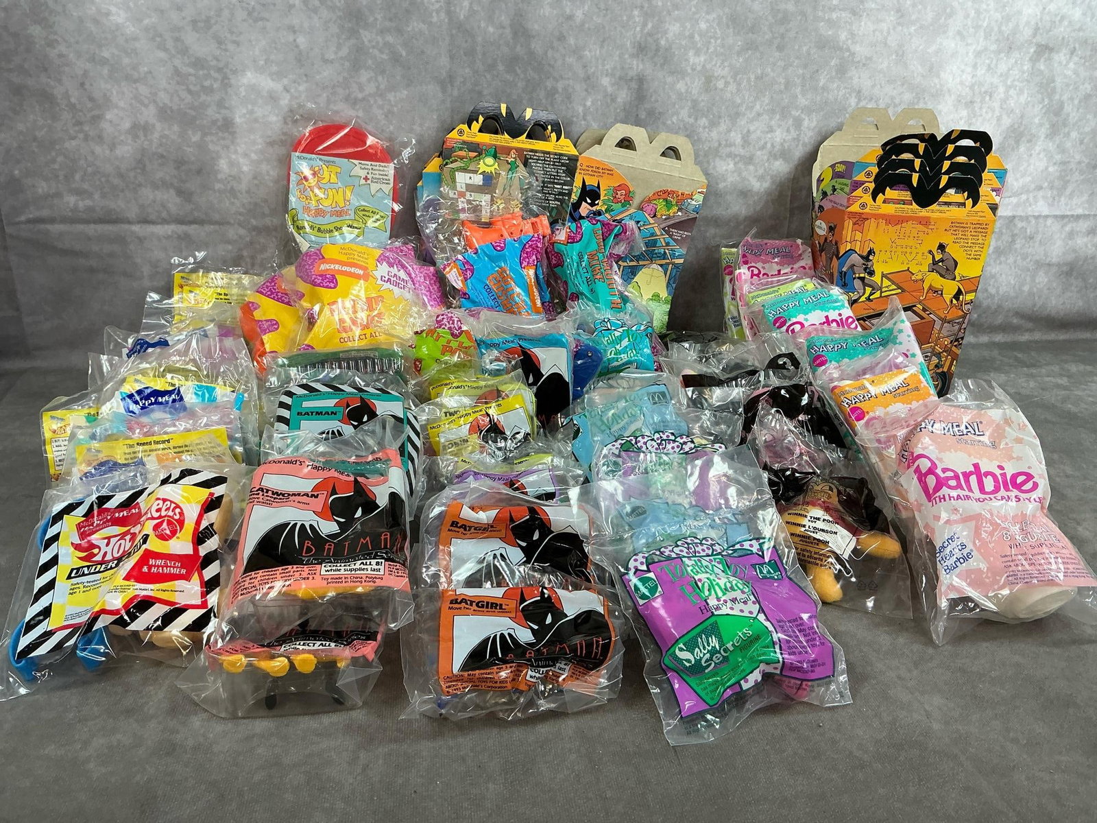 Happy Meal Toys: Sixty 1991-2002 McDonald's toys. Includes Barbie, Winnie-the-Pooh, Holiday Toys, Batman, Hotwheels, and Nickelodeon toys. In original packaging. Average package measures 4 inches wide x 5 inches tall.
