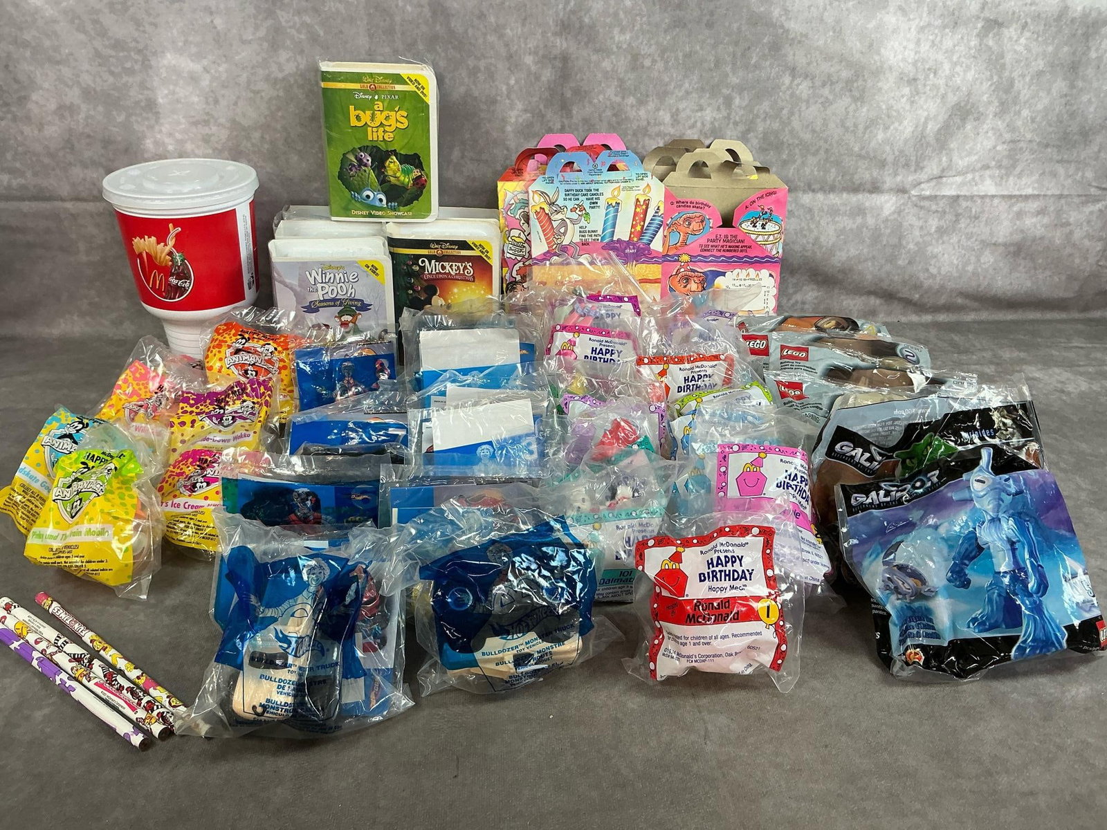 Assorted McDonald's Toys: Forty-eight 1994-2001 Happy Meal toys. Includes Lego, Hotwheels, Animaniacs, Disney Video Showcase, and Happy Birthday meal toys. In original packaging. Average measures 4 inches wide x 5 inches tall.