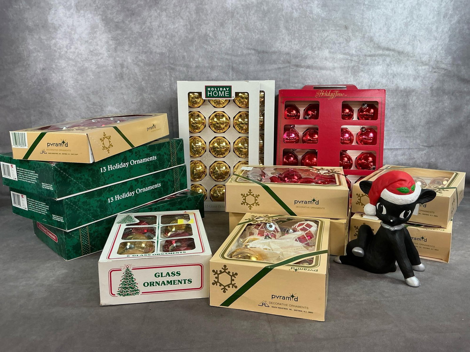 Vintage Glass Christmas Tree Ornaments: One hundred and thirty-six late 1900's Christmas bulbs. Twelve boxes complete (and a partial box) of red and gold glass ornaments. Includes a ceramic black deer. In good condition. Green box measures