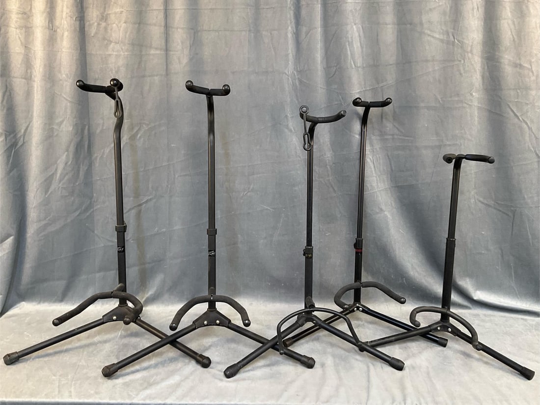 Guitar Stands: Five Contemporary Guitar Stands. Two Peavey, one Adam, one Musician's Gear, and one unmarked. Good condition. Measures 19 inches wide x 12 x 28 inches tall.