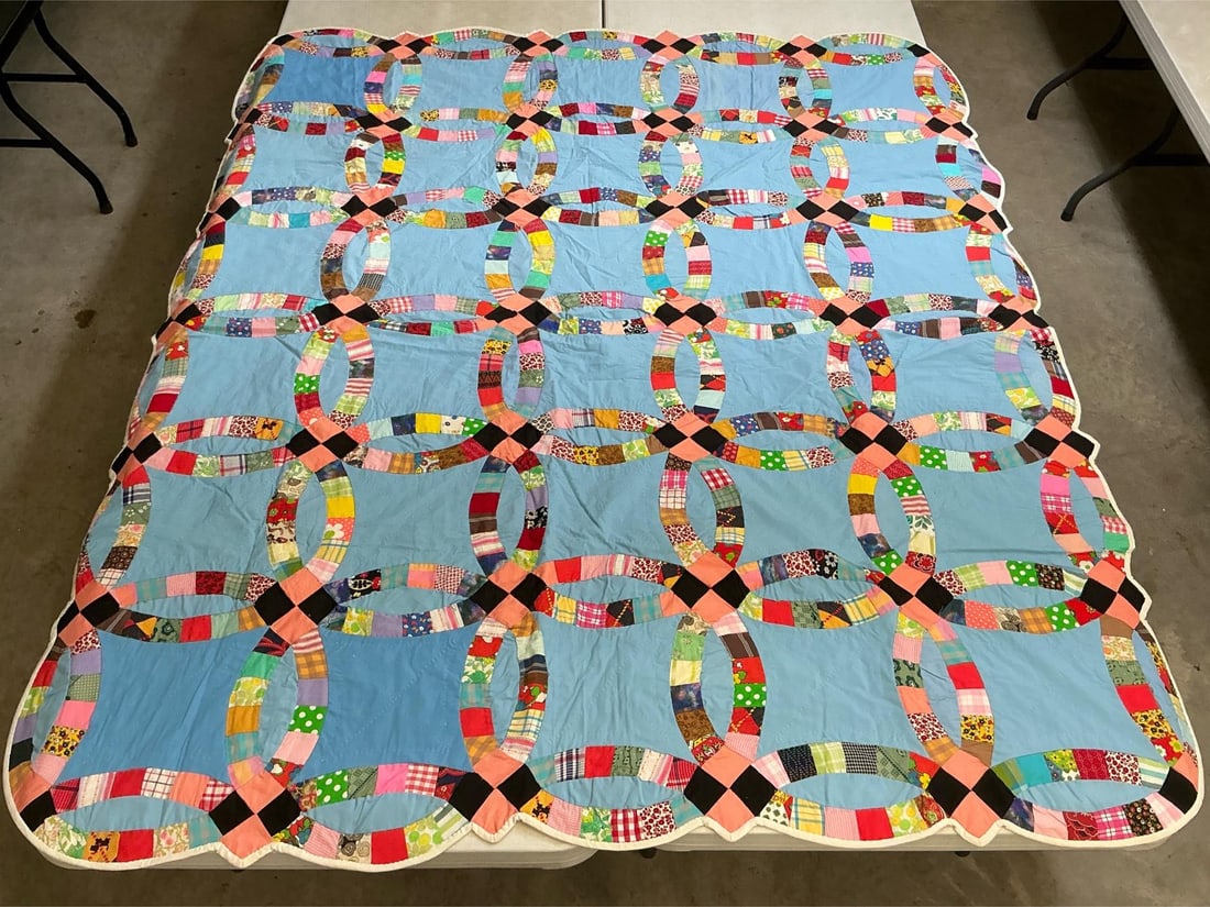 Vintage Quilt: Homemade Double Wedding Ring pattern quilt, machine stitched and hand quilted. Decorative cut edges all the way around. Good condition. Measures 65 inches wide x 77 inches long.