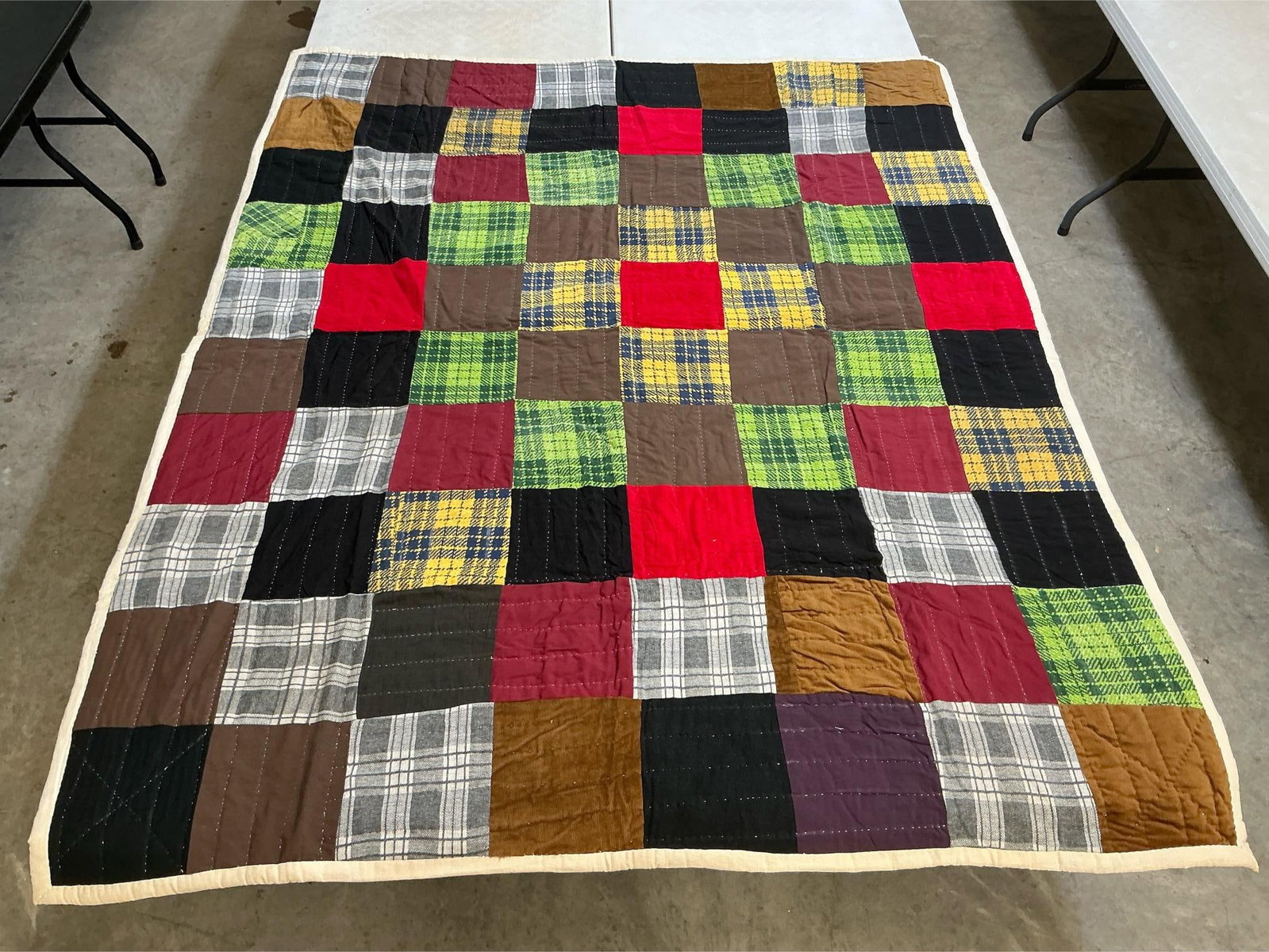 Vintage Quilt: Homemade vintage quilt, machine stitched and hand quilted. Some squares are flannel fabric. Some staining on the back at fold lines, otherwise in good condition. Measures 62 inches wide x 79 inches lo
