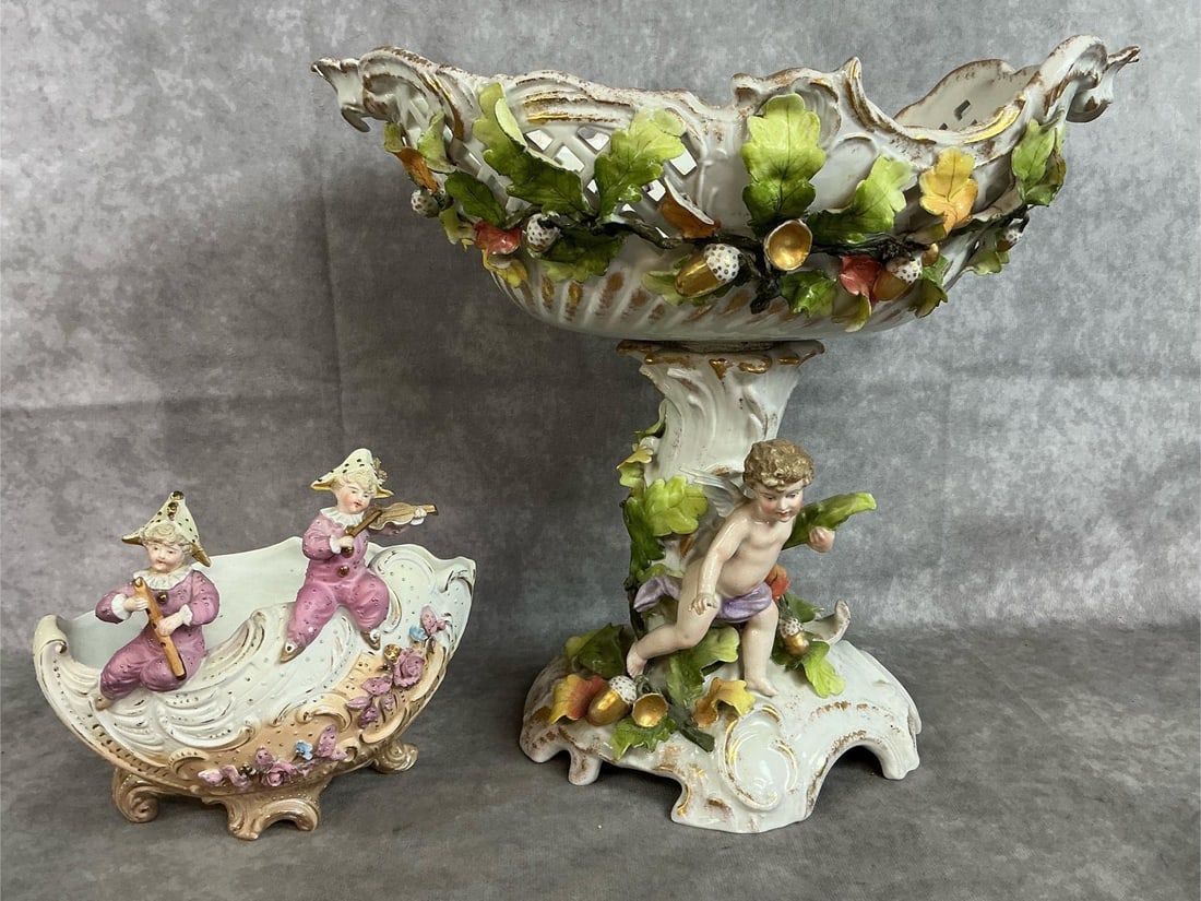 German Antique Centerpieces: Two early 1900's bisque porcelain pieces. Bowl on pedestal, possibly Carl Thieme piece. Decorated with leaves and acorns with a cherub. Includes bowl with two children dressed as jesters. Tall