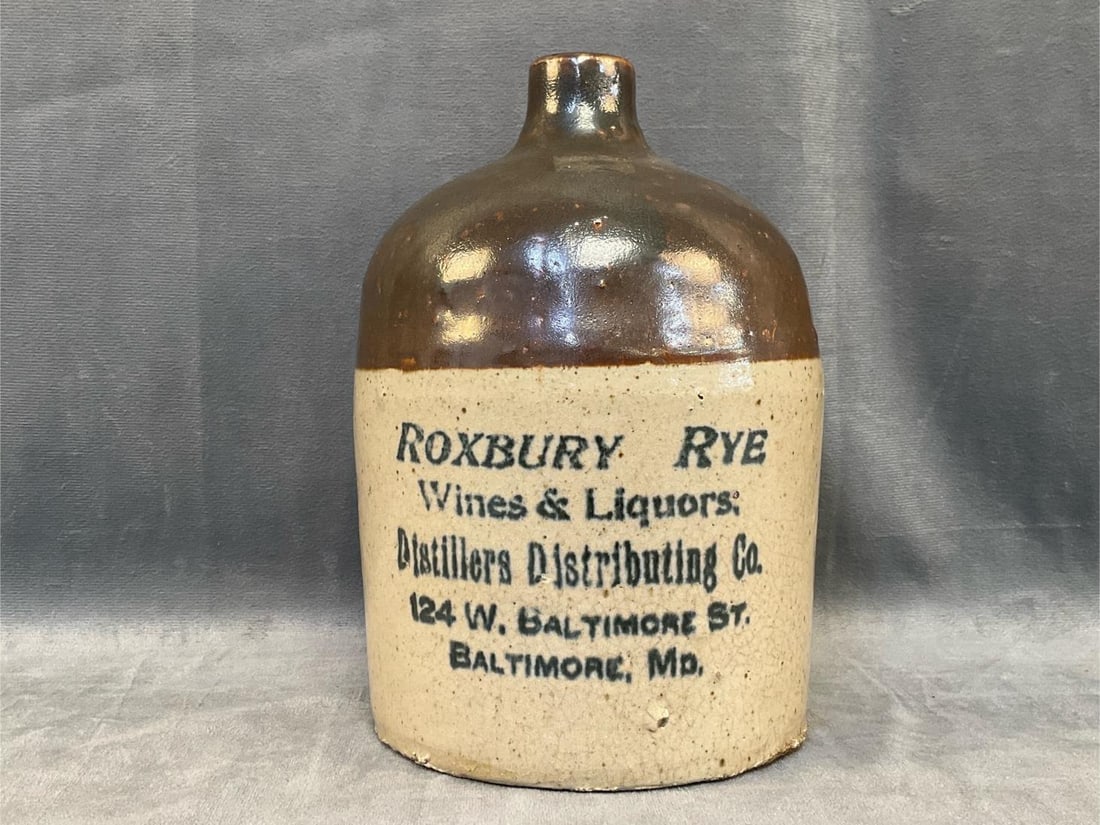 Baltimore Advertising Stoneware Jug: Circa 1900 Baltimore Liquor Merchant's Advertising Stoneware Jug with upper Albany slip glaze and lower Bristol slip glaze. Lower section with advertising ""ROXBURY RYE / Wines and Liquors; /