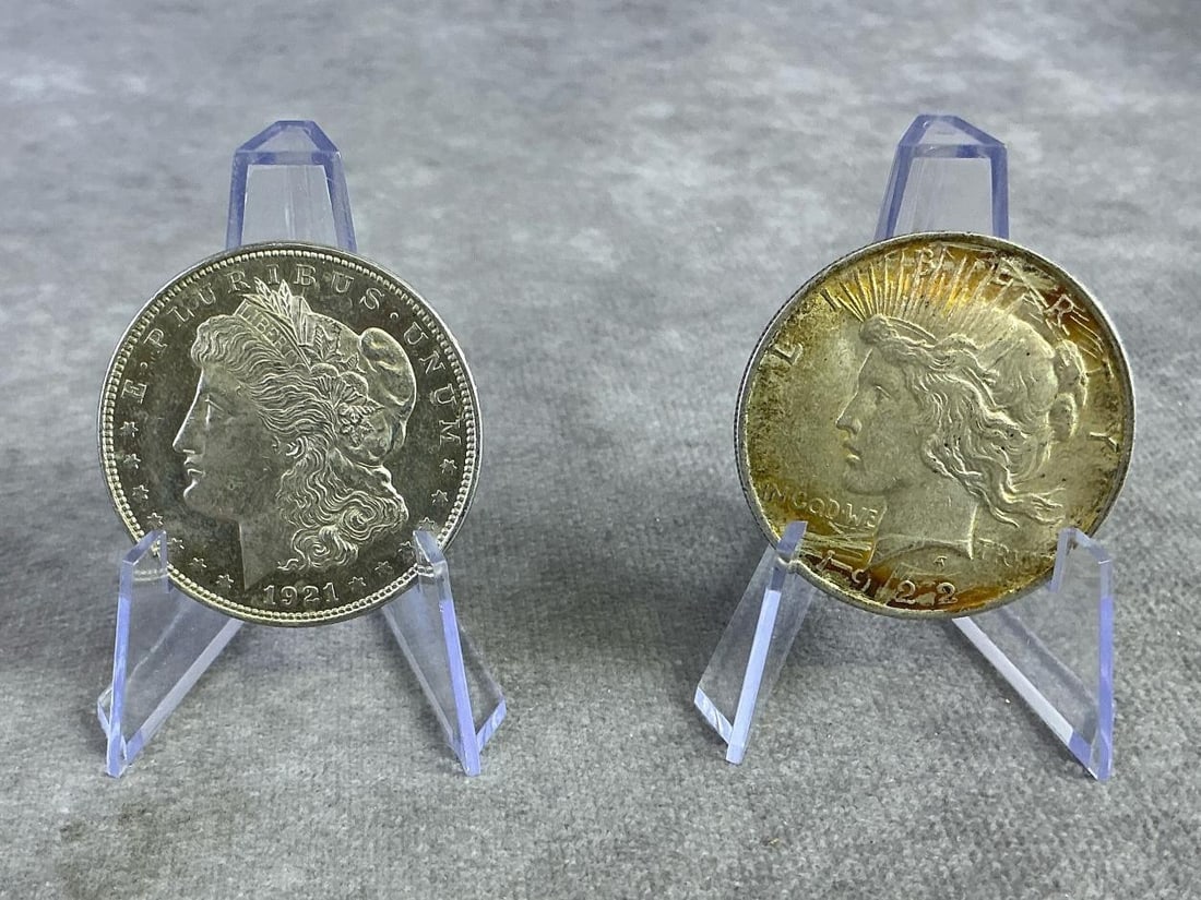 US Coins: 1922 United States Peace Dollar and 1921 United States Morgan Silver Dollar. Composed of 90 percent silver, in good circulated condition. Total weight 1.71 ozt.