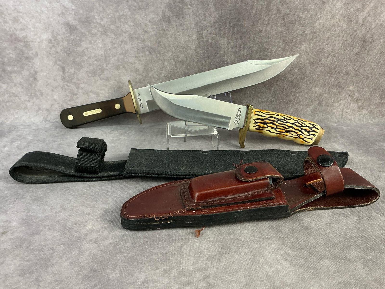Schrade Fixed Blade Knives: Schrade Old Timer Bowie knife with sheath. Blade marked Schrade SCPROM-13-3. Schrade Uncle Henry Pro Hunter knife with leather sheath and sharpening stone. Blade marked Uncle Henry Schrade 171UH.