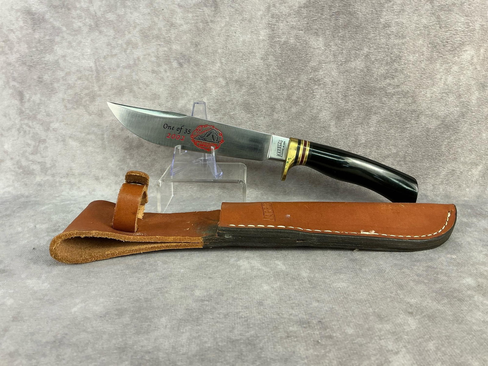 Marbles Fixed Blade: 2002 Old Dominion Knife Collector's Association fixed blade knife with leather sheath. Made by Marble's Gladstone, MI USA. Never been sharpened, verdigris on guard. Knife measures 10 inches long.