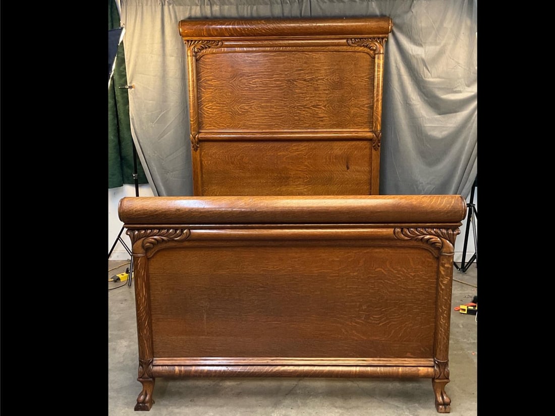 Victorian Oak Bed: Late 19th - early 20th century oak bed with carved headboard and paw feet. Both paw feet damaged and side rail reinforced with contemporary modern bolts, otherwise good condition. Measures 60 inches