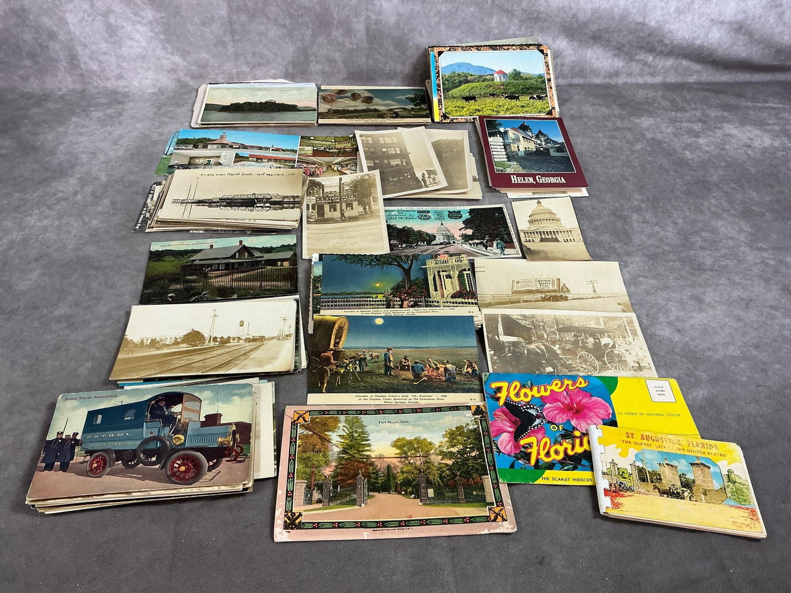 Vintage Postcards: Approximately 180 postcards from early to mid 1900's. Includes US city sites, travel, scenes from old songs, vehicles, and more. Some wear and use. Average card measures 6 inches wide x 4 inches tall.