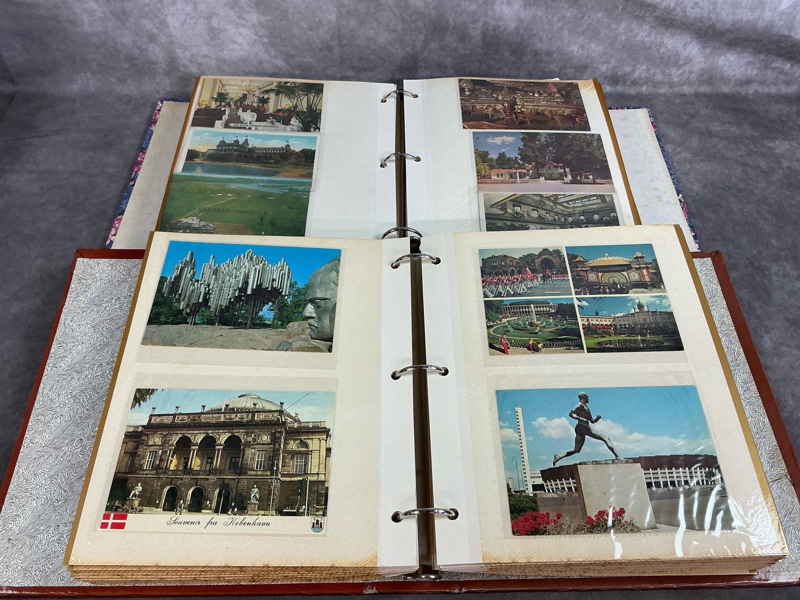Postcards of Famous Places & Hotels: Two albums containing over 200 postcards each from early 1900's to mid century. Both have cards from around the world. Albums are yellowed, cards in good condition. Albums measure 10.5 inches wide x