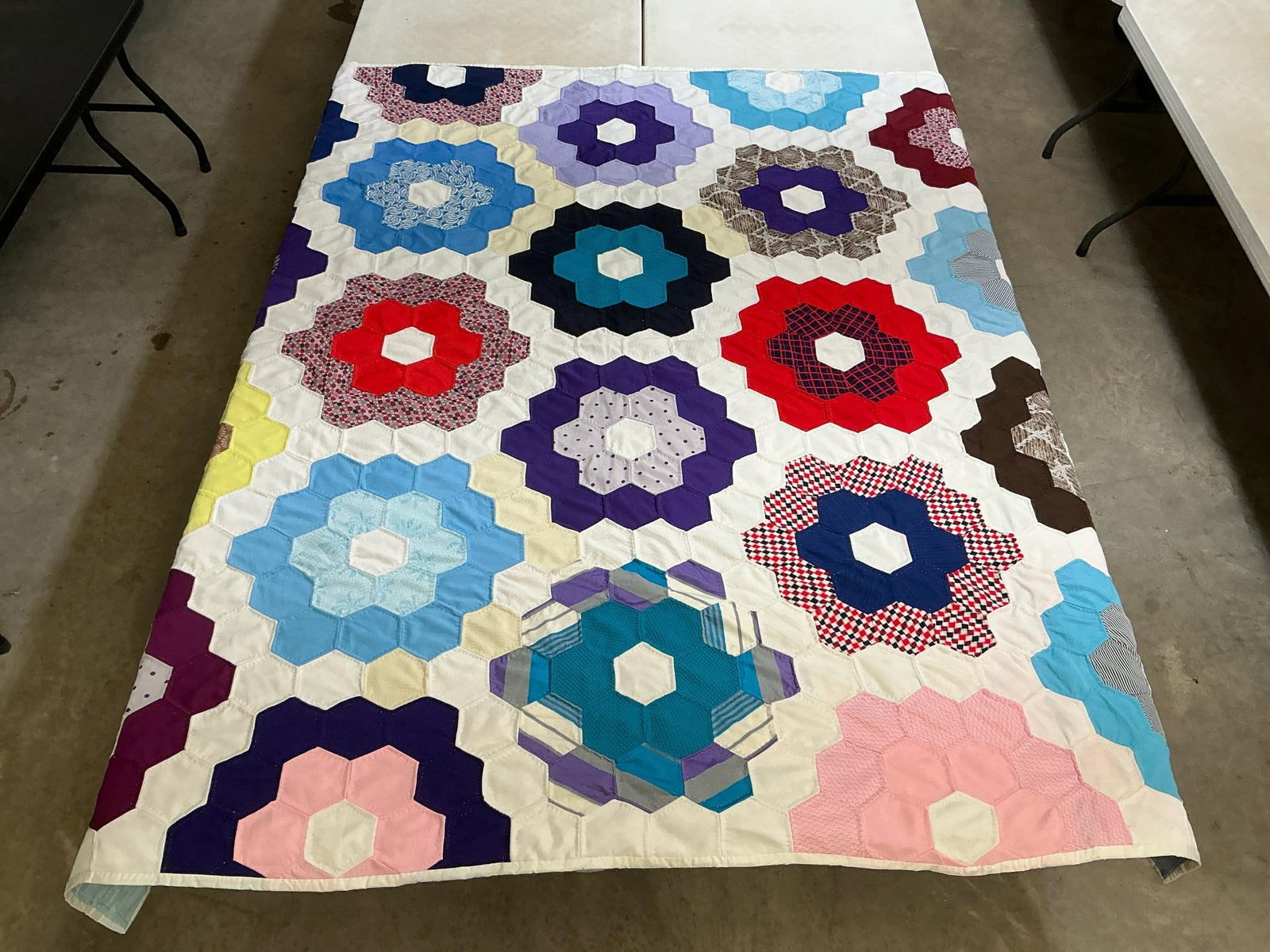 Grandmother's Flower Quilt: Vintage homemade grandmother's flower pattern quilt, 100% polyester. Has stains on the back at fold lines and from what appears to be tape. Otherwise in good condition. Measures 79 inches wide x 79