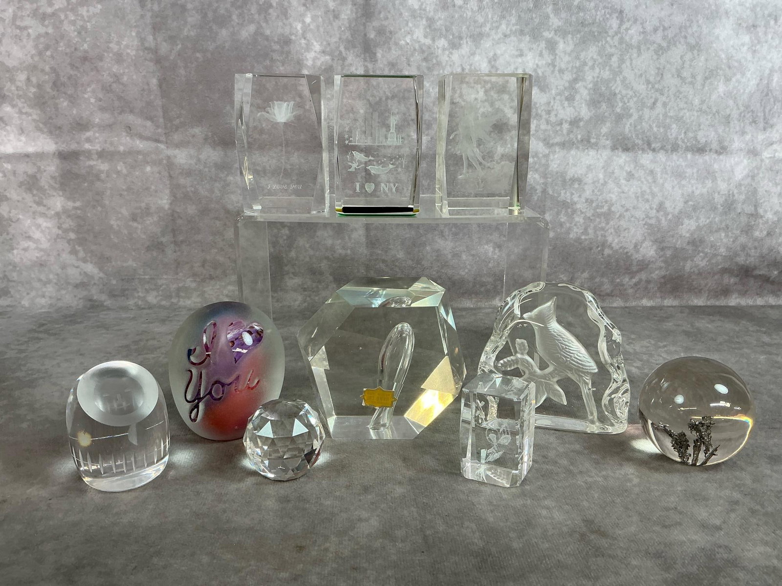 Crystal Cubes, Paperweights, & Prisms: Ten late 1900's art glass paperweights. Three 3D laser etched crystal cubes, plus a mini cube. Two orbs, a prism, etched Artmark cardinal and an optic glass with face. All in good condition. Largest