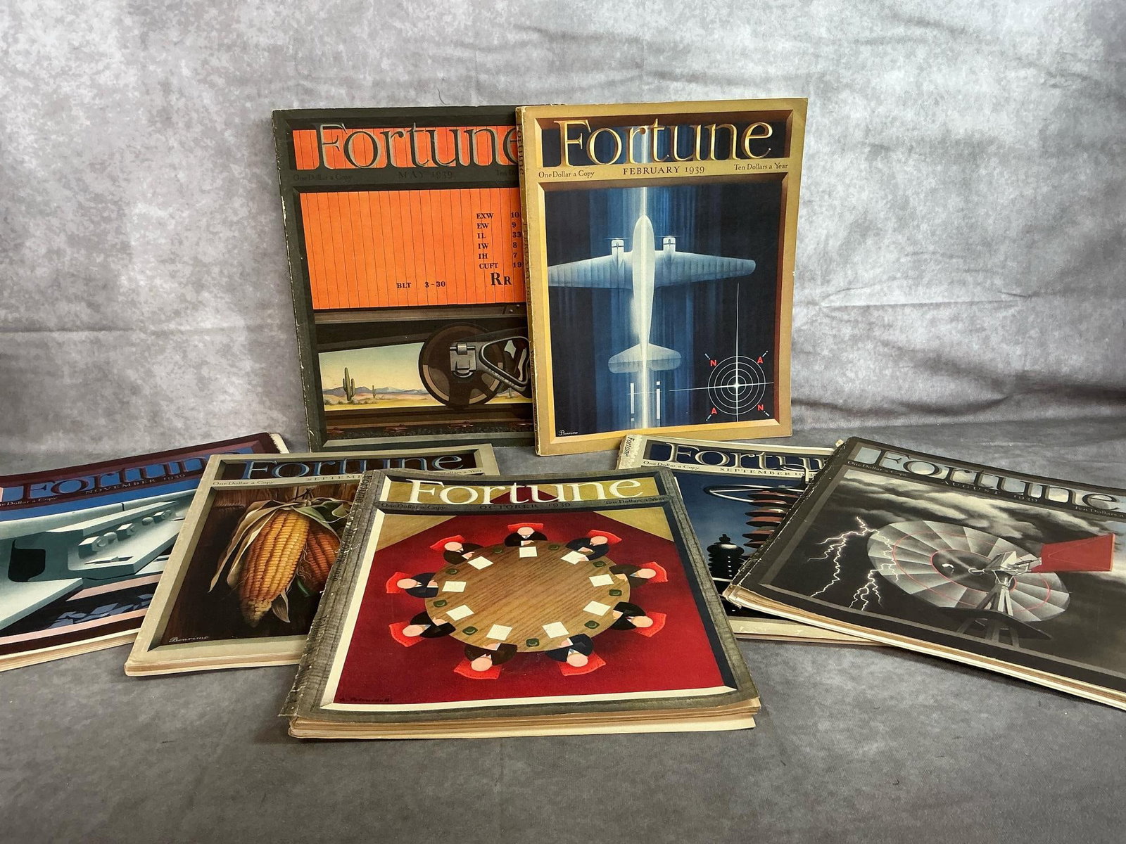 Fortune Magazines 1939: Seven Fortune Magazines from 1939. Some have loose covers and foxing. Each measures 12 inches wide x 14 inches tall.