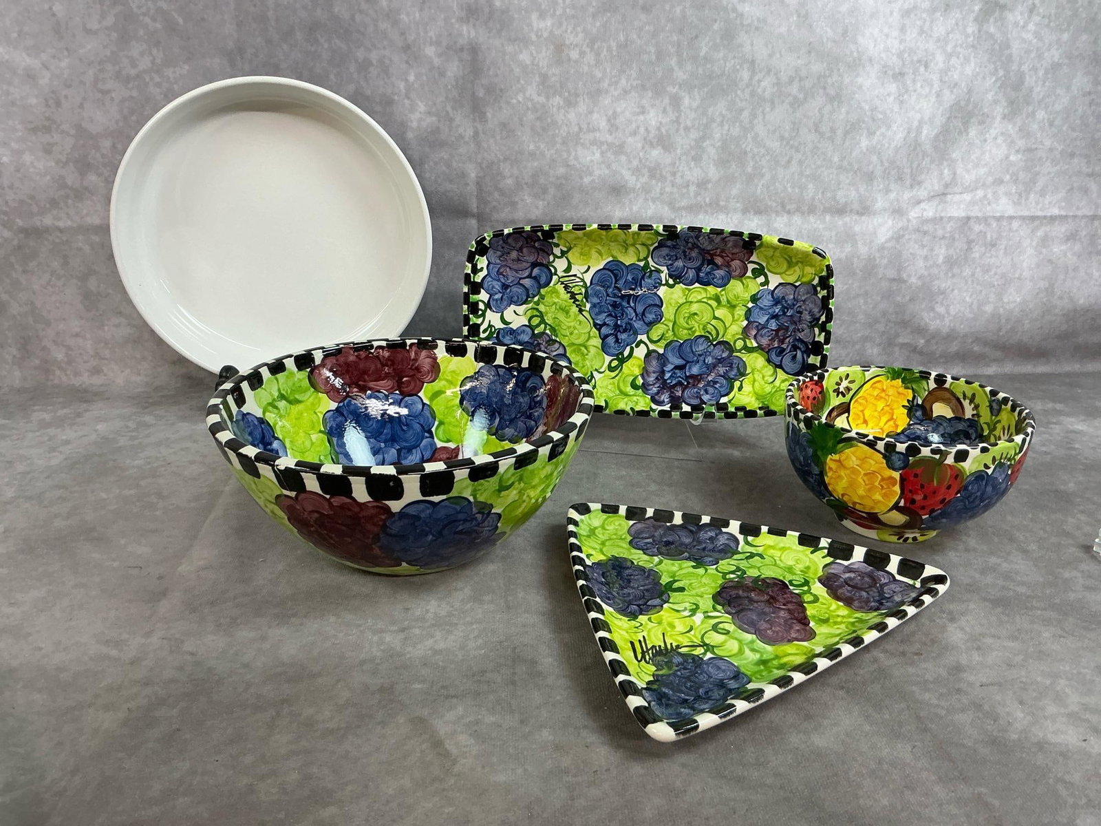 Art Stoneware & Corning Dish: Five stoneware pieces. Handpainted grapes and fruit dishes and small servers signed by artist. Corningware pie or quiche dish. Largest bowl is cracked and repaired, otherwise items in good condition. 