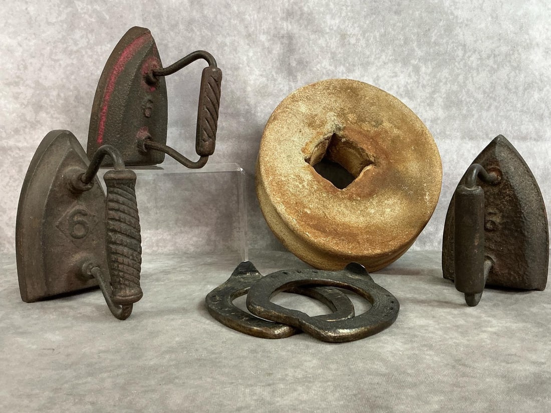 Millstone, Sad Irons, & Horseshoes: Six late 1800's- early 1900's collectible items. Grinding stone or millstone, three cast iron "sad irons" for ironing clothes, and two straight bar horseshoes. Rust present, otherwise items in good