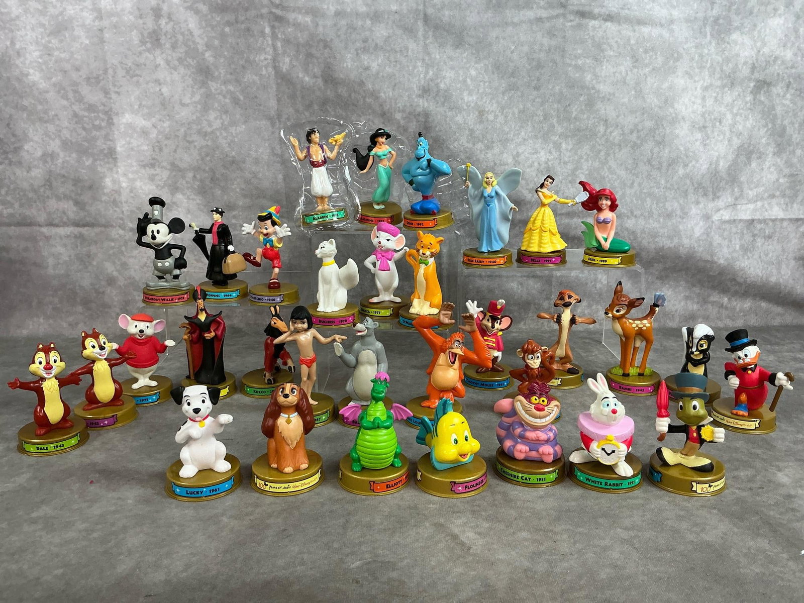 Happy Meal Disney Collectibles: Thirty-two 2002 McDonald's toys celebrating 100 years of Disney. Includes 1928-2000 characters from Disney. In new condition. Measures 2 inches in diameter x 4 inches tall.