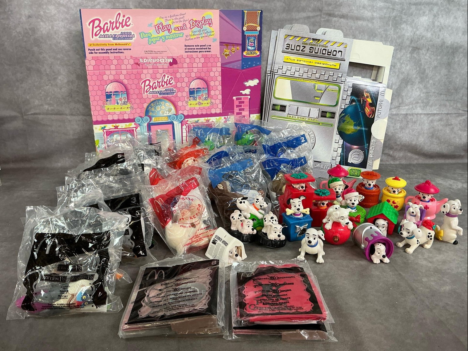 Happy Meal Collectibles: Forty-two McDonald's toys from 2003-2006. Includes 101 Dalmatians, Build-Bear, Lion King 1 1/2, and Pirates of the Caribbean. Also Barbie play and display boxes and Racing Futures display boxes.