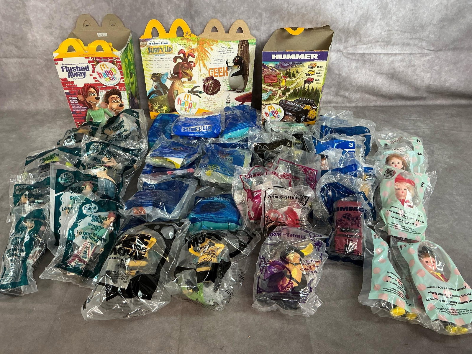 McDonald's Happy Meal Toys: Forty 2006-2007 collectible Happy Meal toys. Includes Flushed Away, Madame Alexander dolls, Surf's Up, Shrek the Third, Hummer, and more. In original packaging. Average measures 4 inches wide x 5