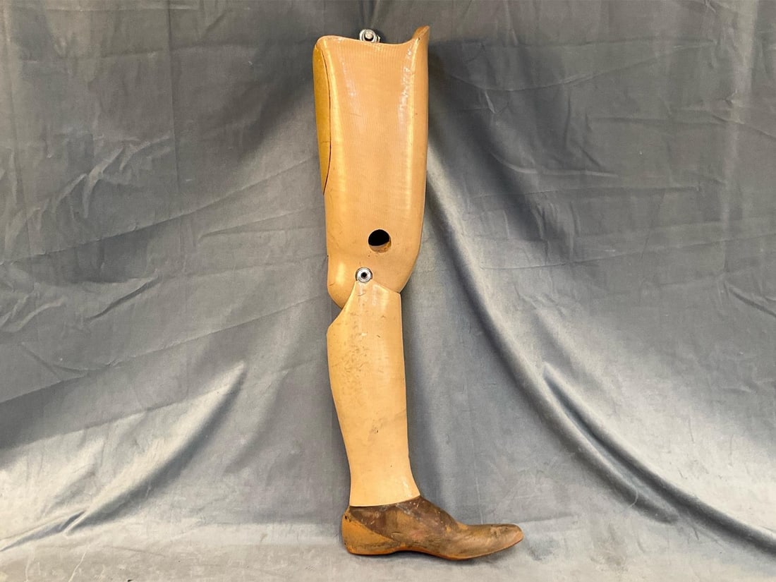 Vintage Prosthetic Leg: Mid-20th century wooden prosthetic left leg with leather covered foot. Signs of wear commensurate with age and use, overall good condition. Measures 11.5 inches wide x 1 x 32 inches tall.