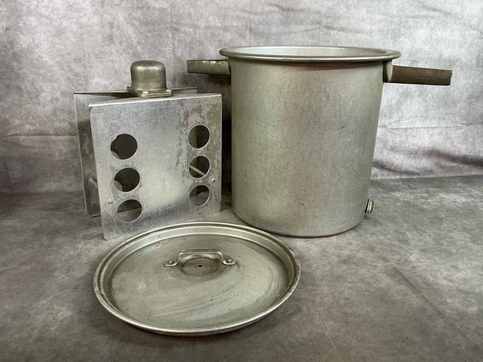 Aluminum Butter Churn: Vintage Maytag butter churn fits in tub washing machine. Made of aluminum with lid, agitator, and handles. Wear related to age. Measures 13.5 inches in diameter x 13 inches tall.