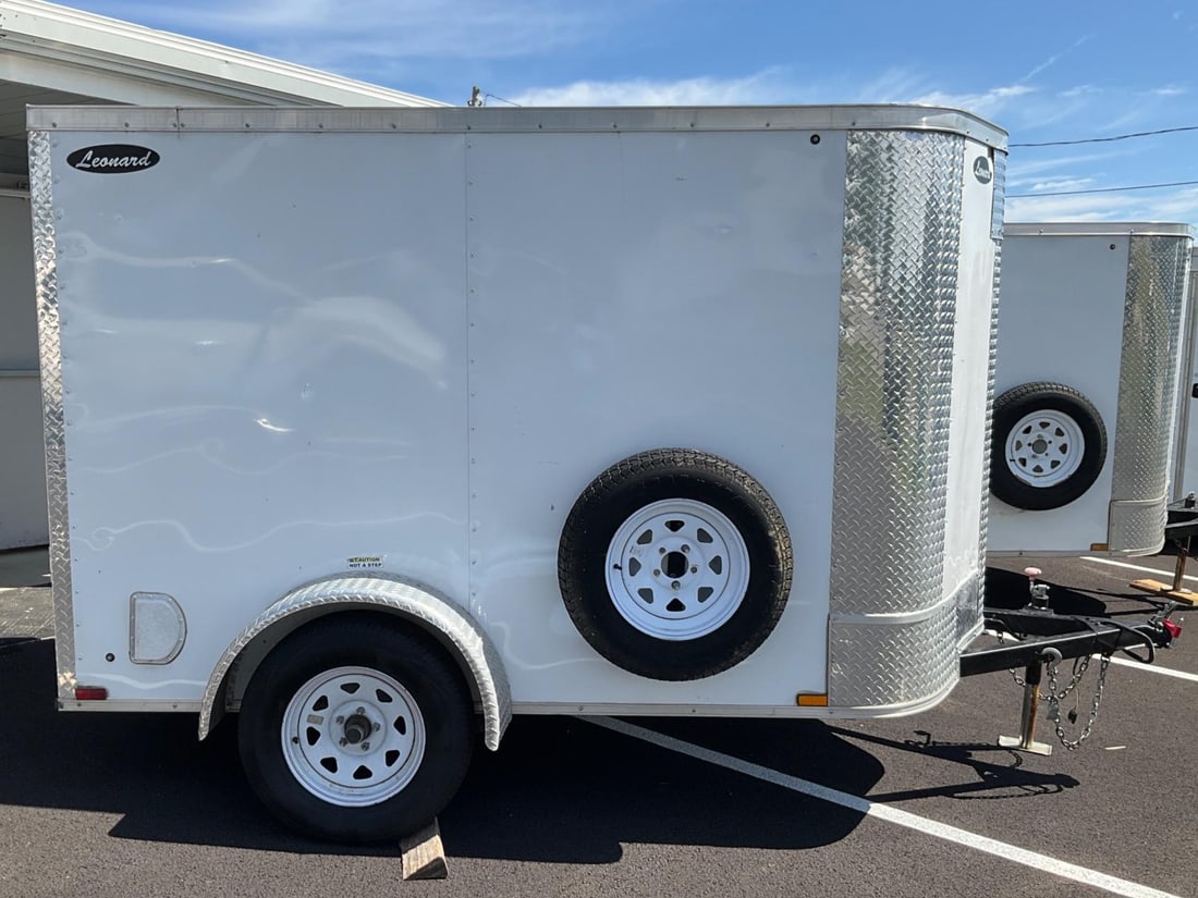 Leonard Trailer: 2021 enclosed, white, Leonard 5’x8’ pull behind rounded V-Nose single axel trailer. Model number 58VSRW. Single rear fold down door. Inside has been fitted with custom wood shelving for tools,